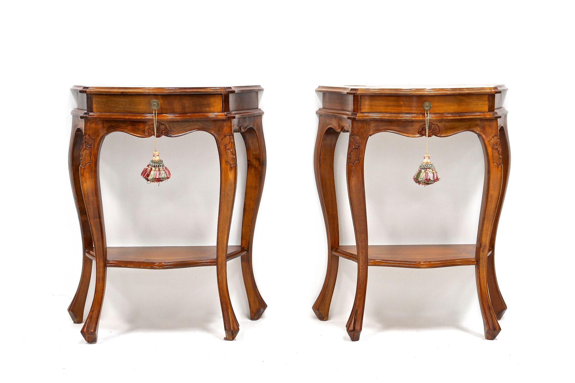 Elegant pair of mid 20th century baroque style nutwood nightstands/ console tables from the period around 1950 in Italy. Beautifully curved, slender nutwood legs, adorned by additional small carvings confer these nightstands an amazing look. Each