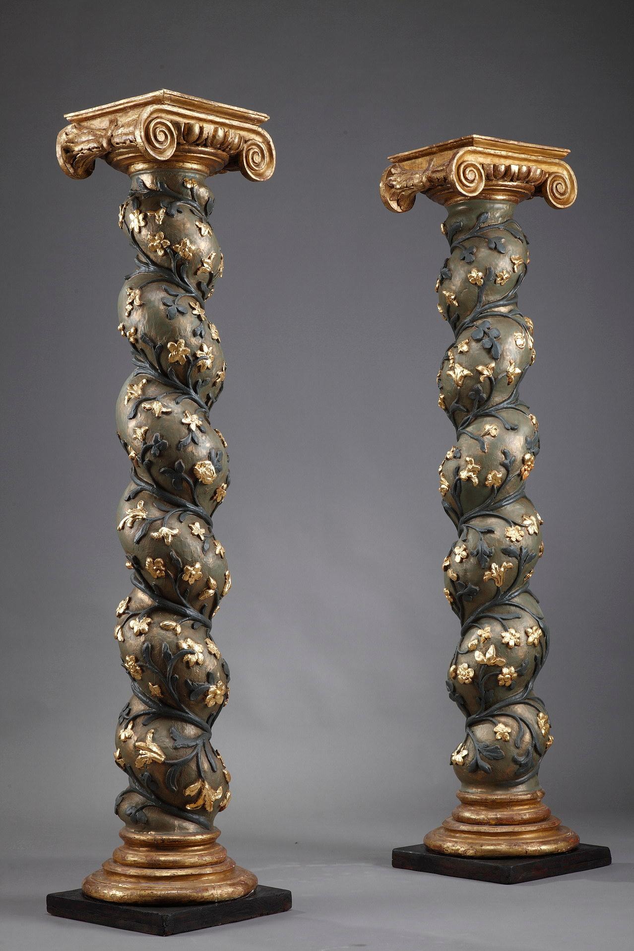 Pair of twisted columns in polychrome lacquered wood decorated with branches and gilded flowers. They rest on molded bases and end with Ionic capitals connected by a frieze of ovals.

Often used in the baroque period, we can find similar ones on