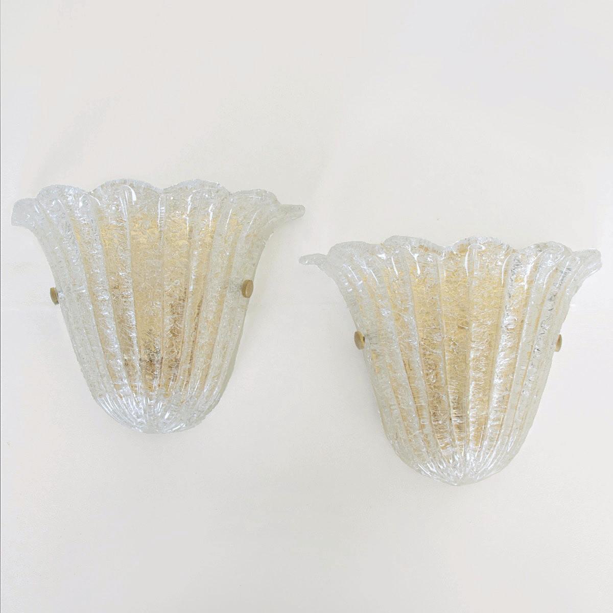 Beautiful pair of glass sconces with scalloped top edge by Barovier & Toso, Italy, 1980's. Ribbed clear class with brass plated back plate. Newly rewired with single socket in each. Illuminates beautifully. 