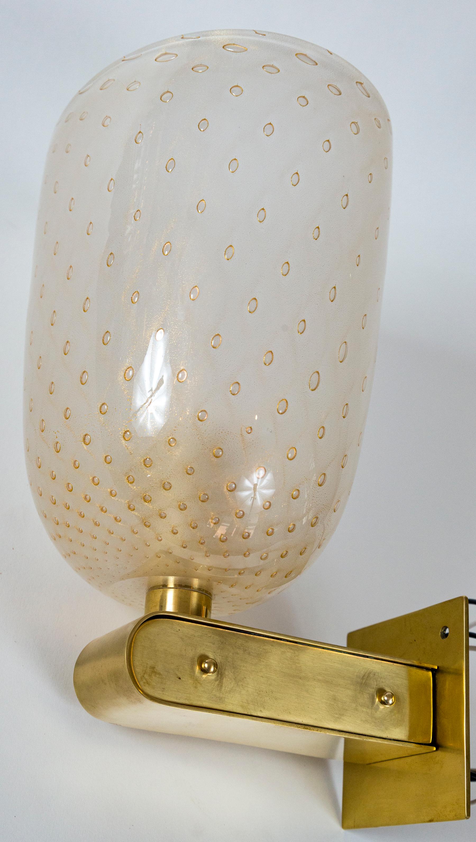 Pair of Murano “pulegoso” glass and brass sconces, modified art deco brass arm upholds a large handblown oval shape ivory blown glass cup with gold infused 23-karat gold bubbles.
Two pairs available, priced per pair
Origin: Venice, Italy
Dating: