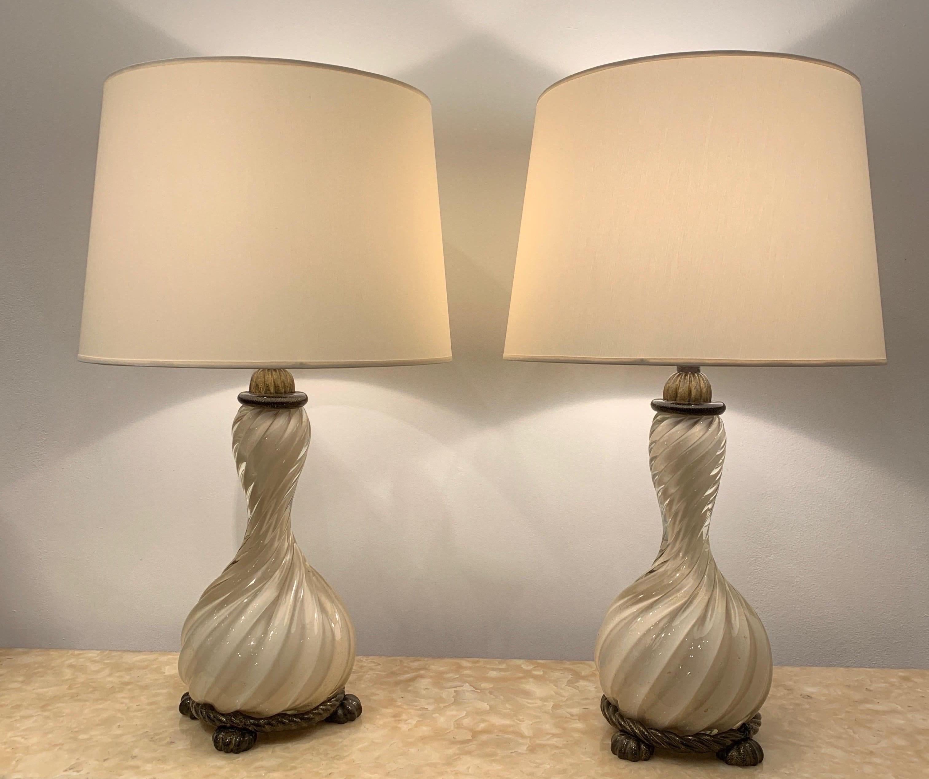 The pair of lamps dates from the 1940s. It has a magnificent Baroque twist. The Cristal glass is white colored with gold sprinkles. Black feet and the top are similarly decorated with gold sprinkles.
Barovier is a reputable Murano Glassmaker. His