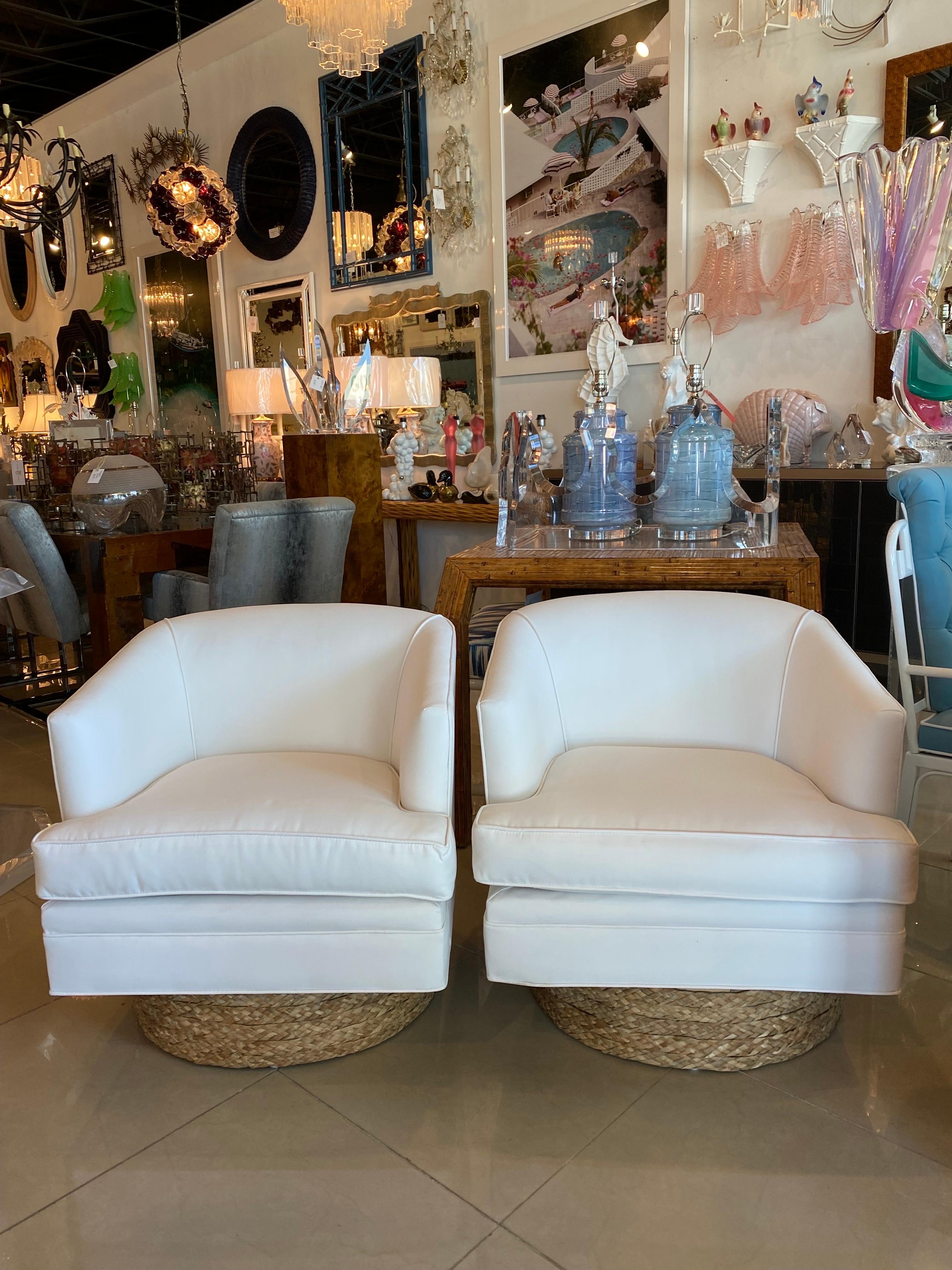 Lovely pair of vintage Milo Baughman style swivel chairs newly upholstered in a Sunbrella white fabric. Perfect for indoors or patio. New foam and insides. Seagrass base. Dimensions: 26.5 H x 30 overall depth x 27 W x 17 cushion depth x 18 seat