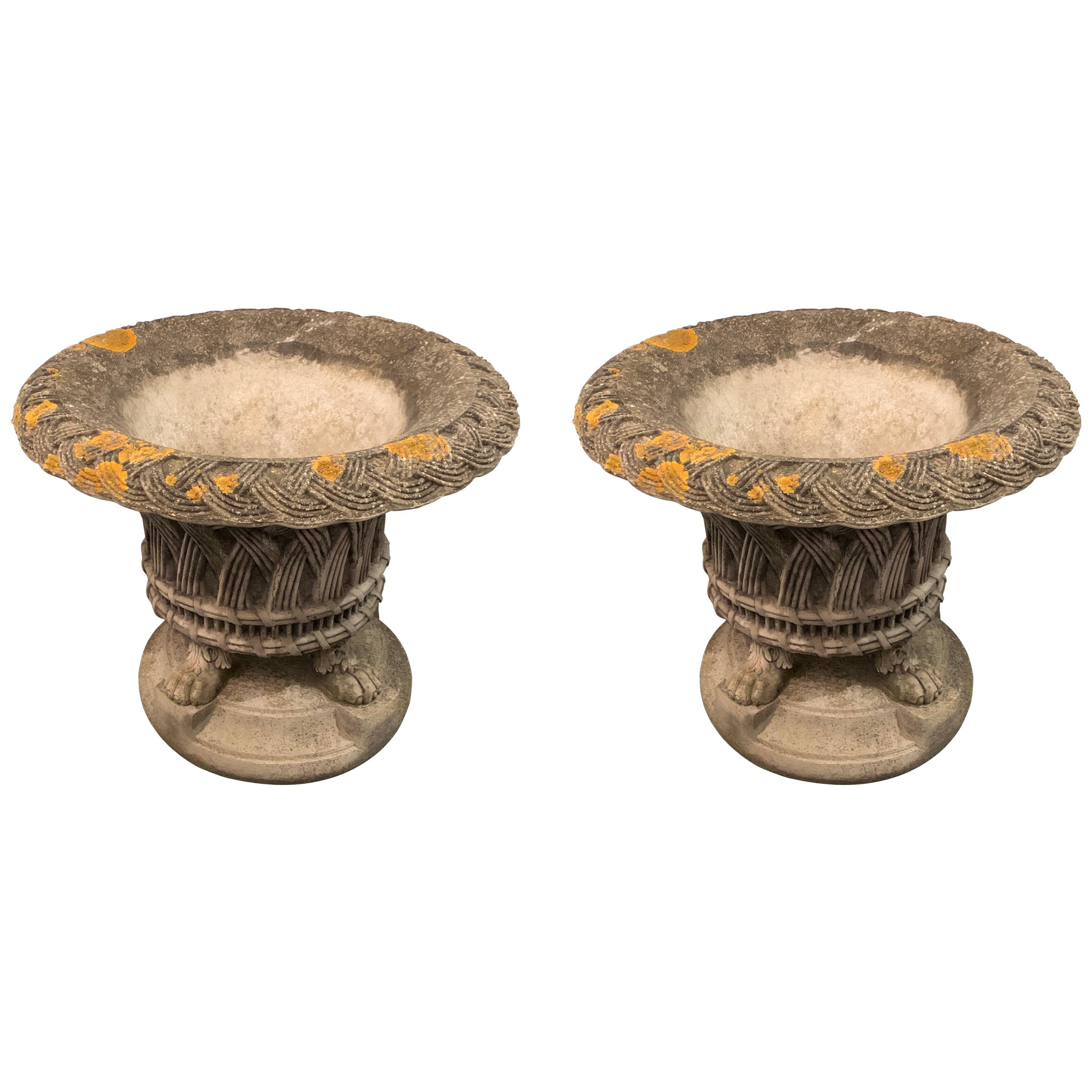 1930s English pair of basket weave patterned planters on four feet.
The Classic design planters sit on top of a round stone plinth.
Original and natural patina with lichen and spores embedded in stone.
Interior depth 15