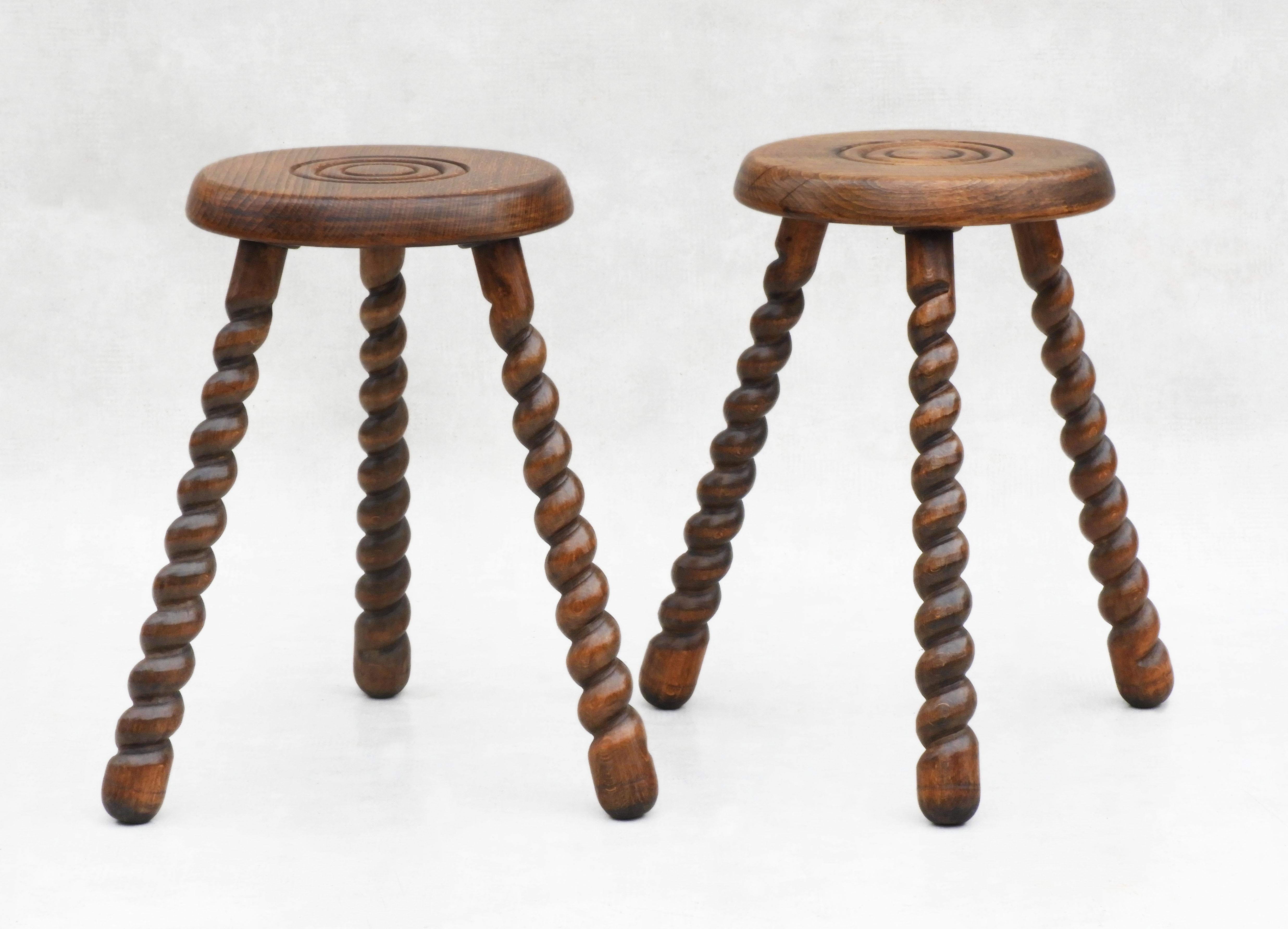 Fabulous pair of oak tripod stools from mid-century France.  Beautifully turned and carved with barley twist legs and circular seats.  Versatile three-legged tabouret stools, which could also be used as nightstands or side tables.  Good grain with