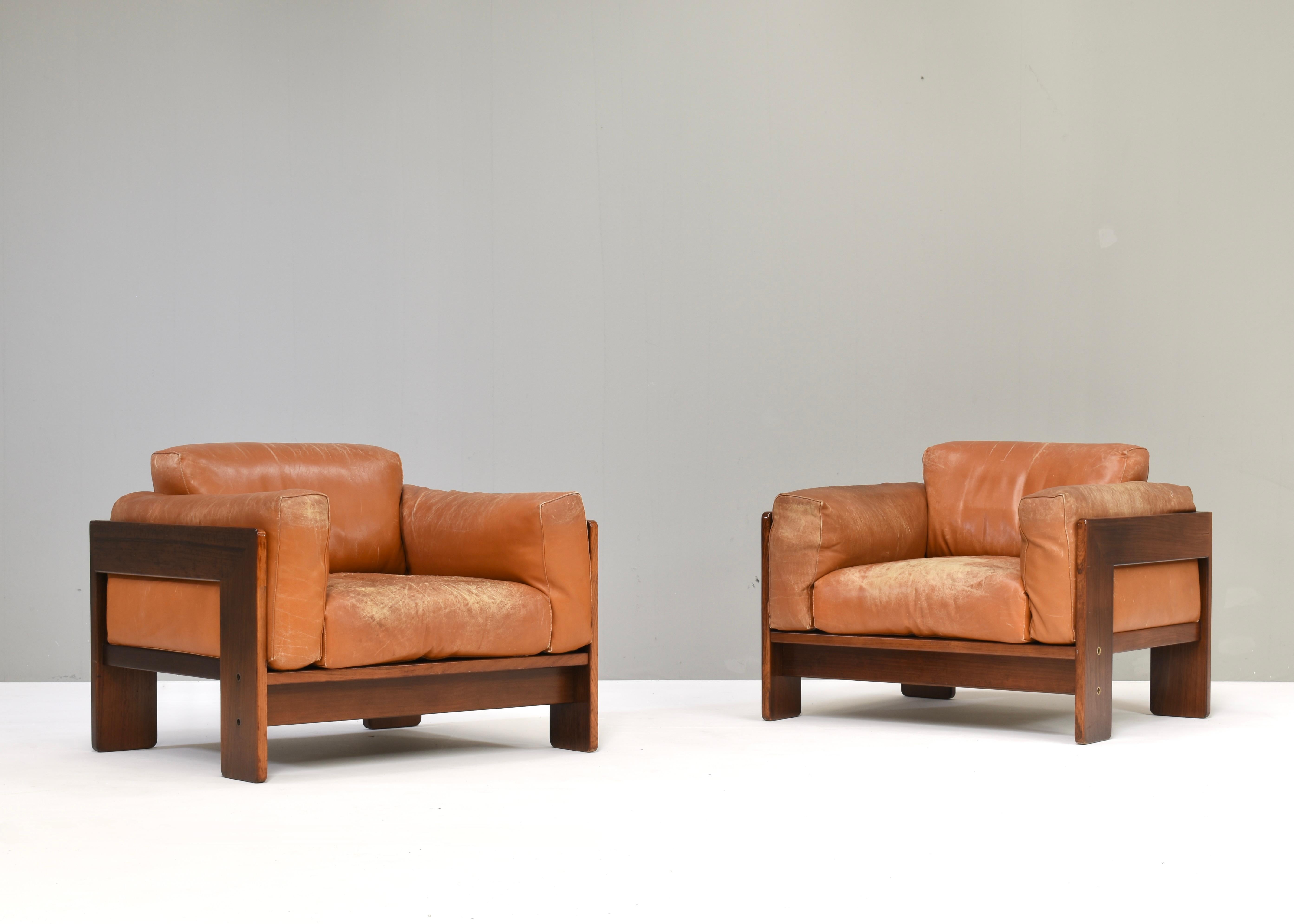 Early pair of Bastiano lounge armchairs in tan leather and Italian walnut by Afra and Tobia Scarpa for GAVINA – Italy, 1975.
These chairs are original Italian production by GAVINA. The chairs were also produced by KNOLL.
Both chairs are labeled on