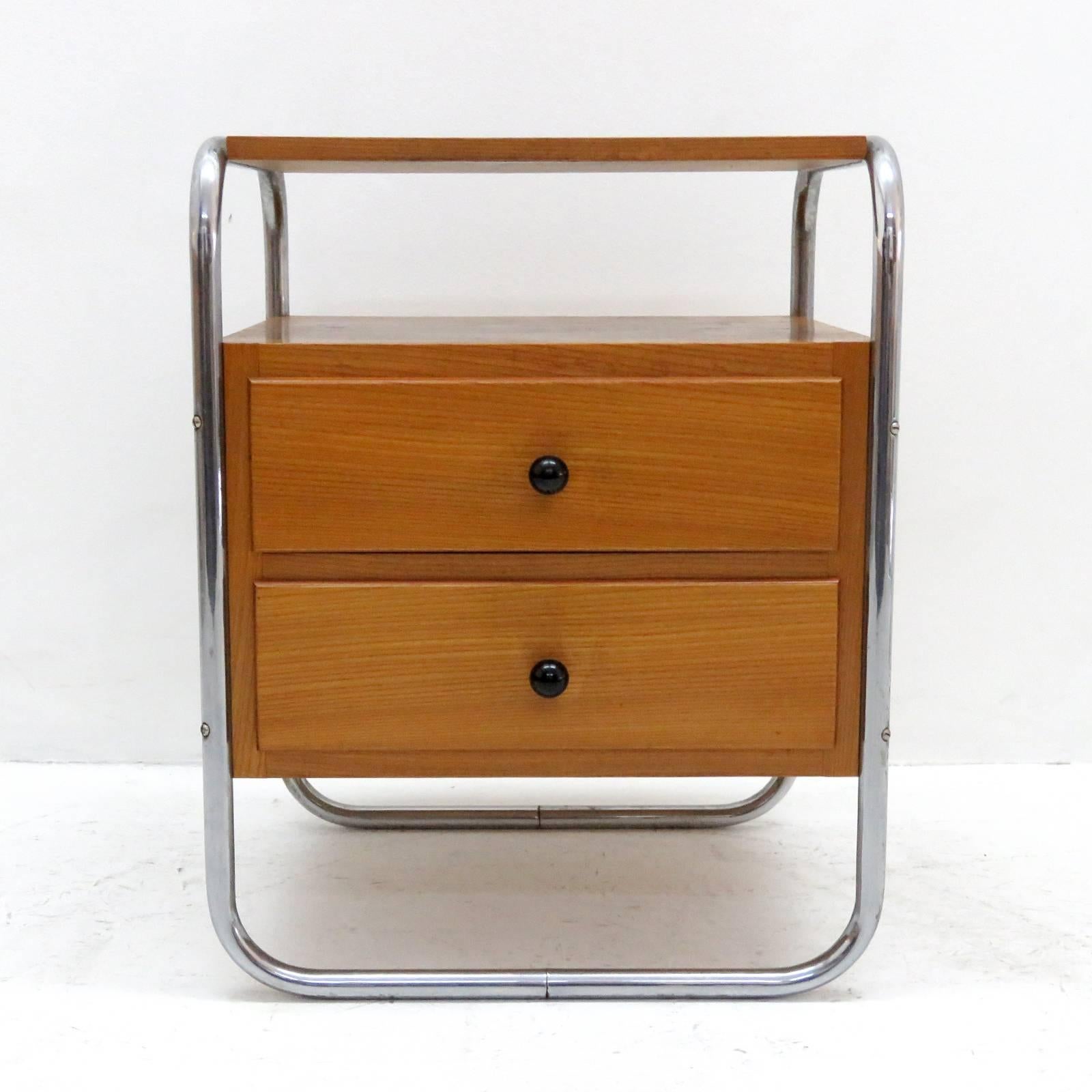 Wonderful pair of Bauhaus era bedside tables in veneered elm, each with two drawers and two shelves, tubular frames of chrome-plated metal.