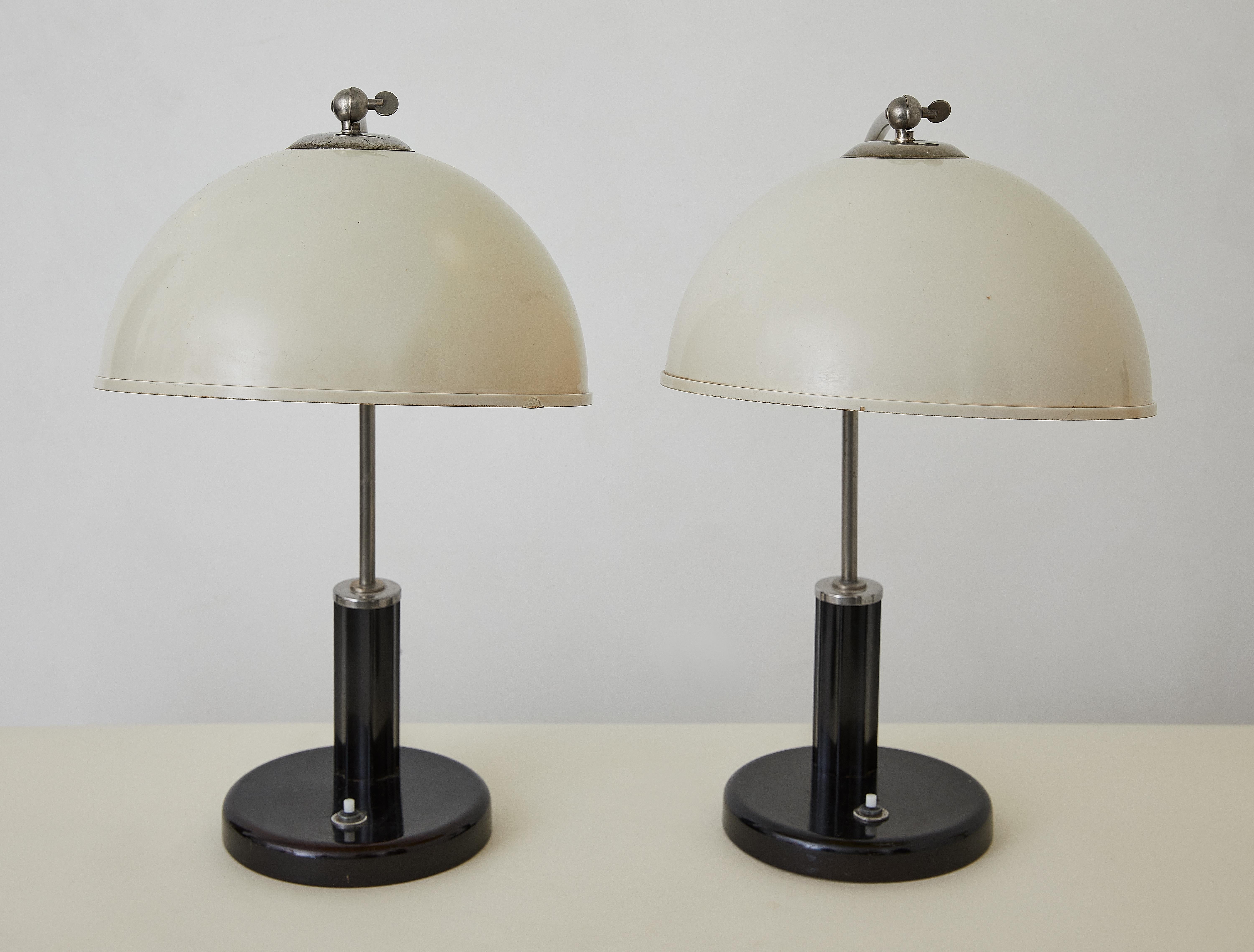 Cette rare paire de lampes de bureau Bauhaus, conçue par Christian Dell pour Kaiser Idell, illustre les principes modernistes épurés qui ont défini le travail de Dell au début du XXe siècle. En tant que designer pionnier et maître métallurgiste,