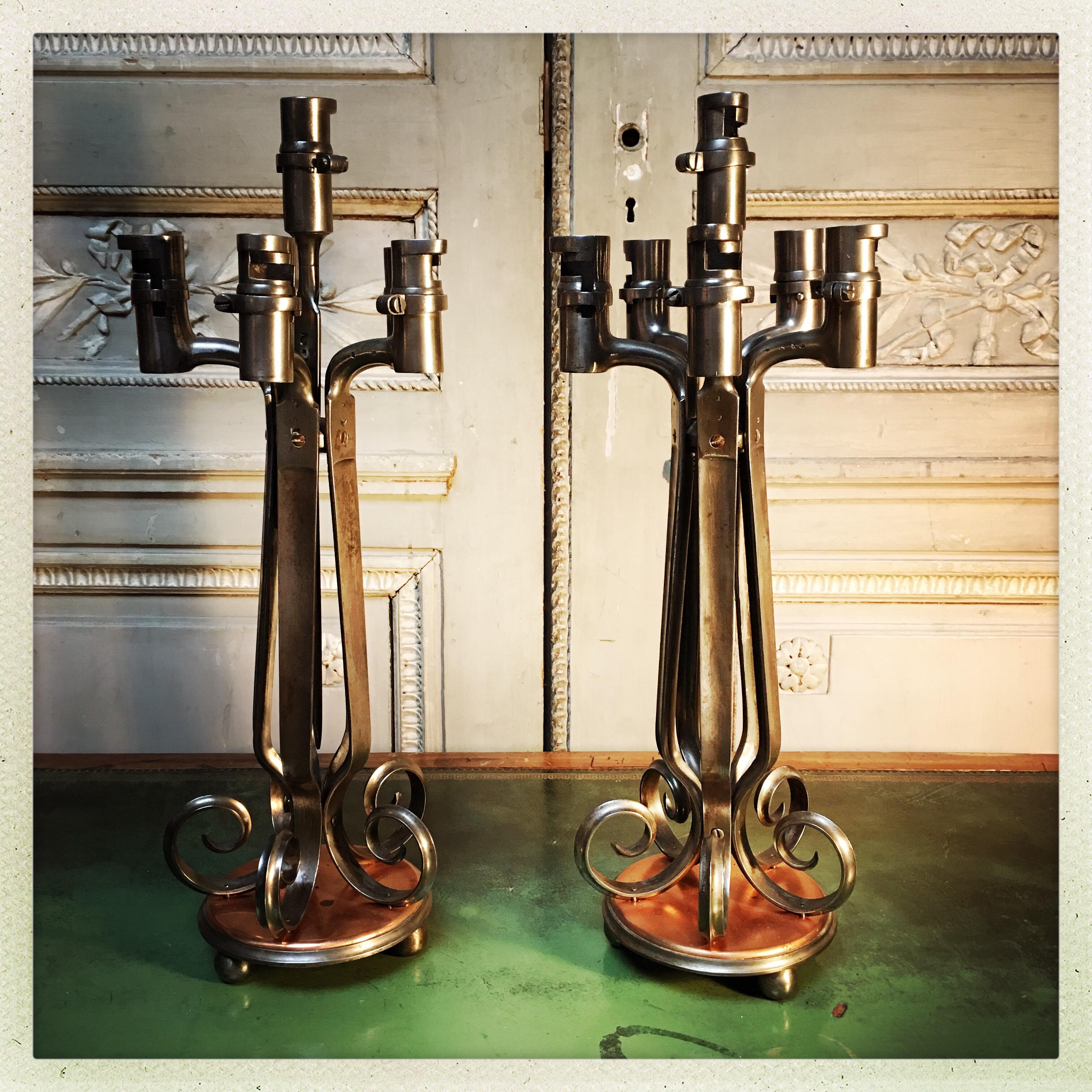 A pair of polished steel and copper candelabra made from old bayonets.