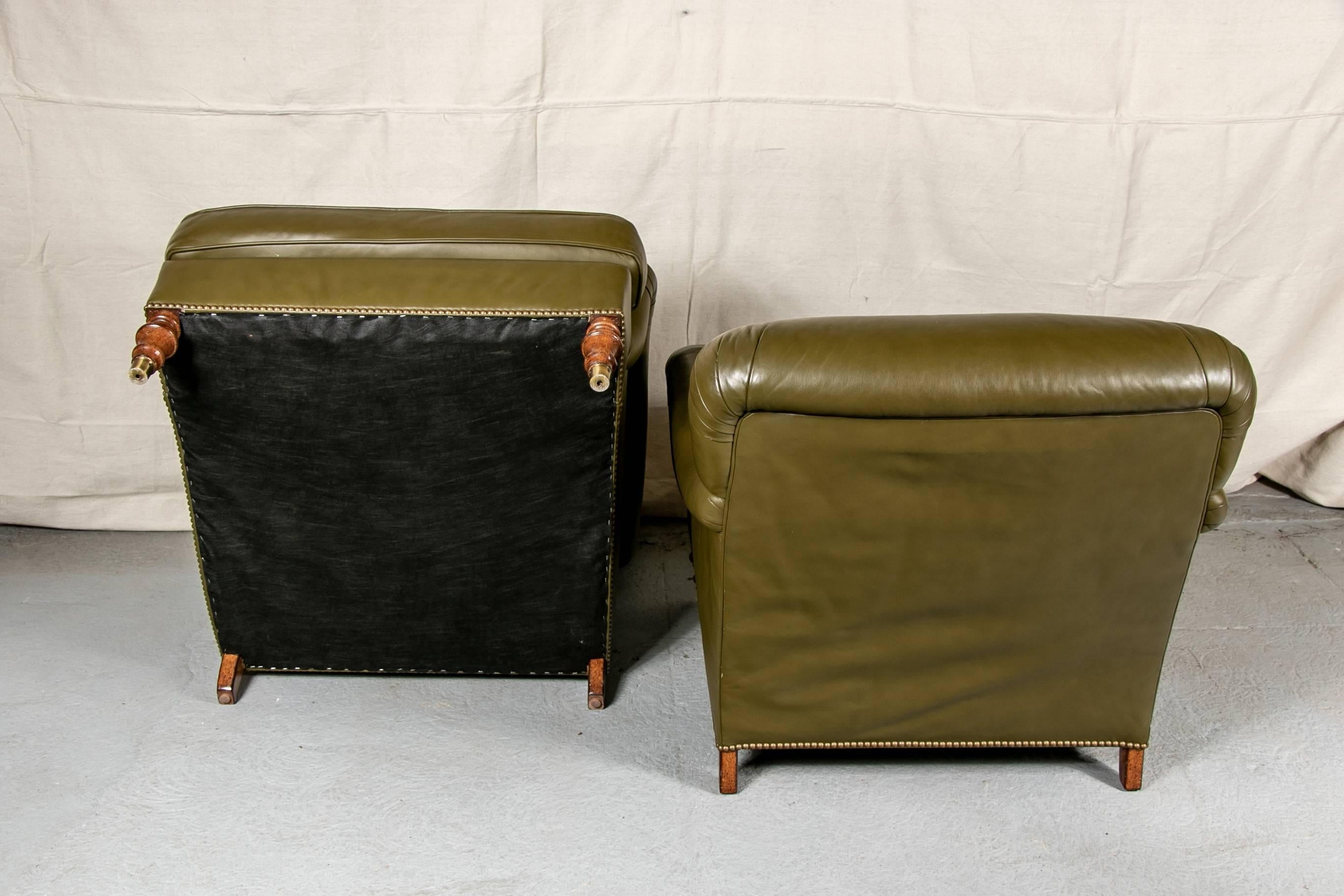 Pair of Beacon Hill club chairs, olive tone leather, the arms and backs with pleated ends, raised on walnut turned feet with brass caps in front and block feet at back. 

Condition: Light scratches to back.