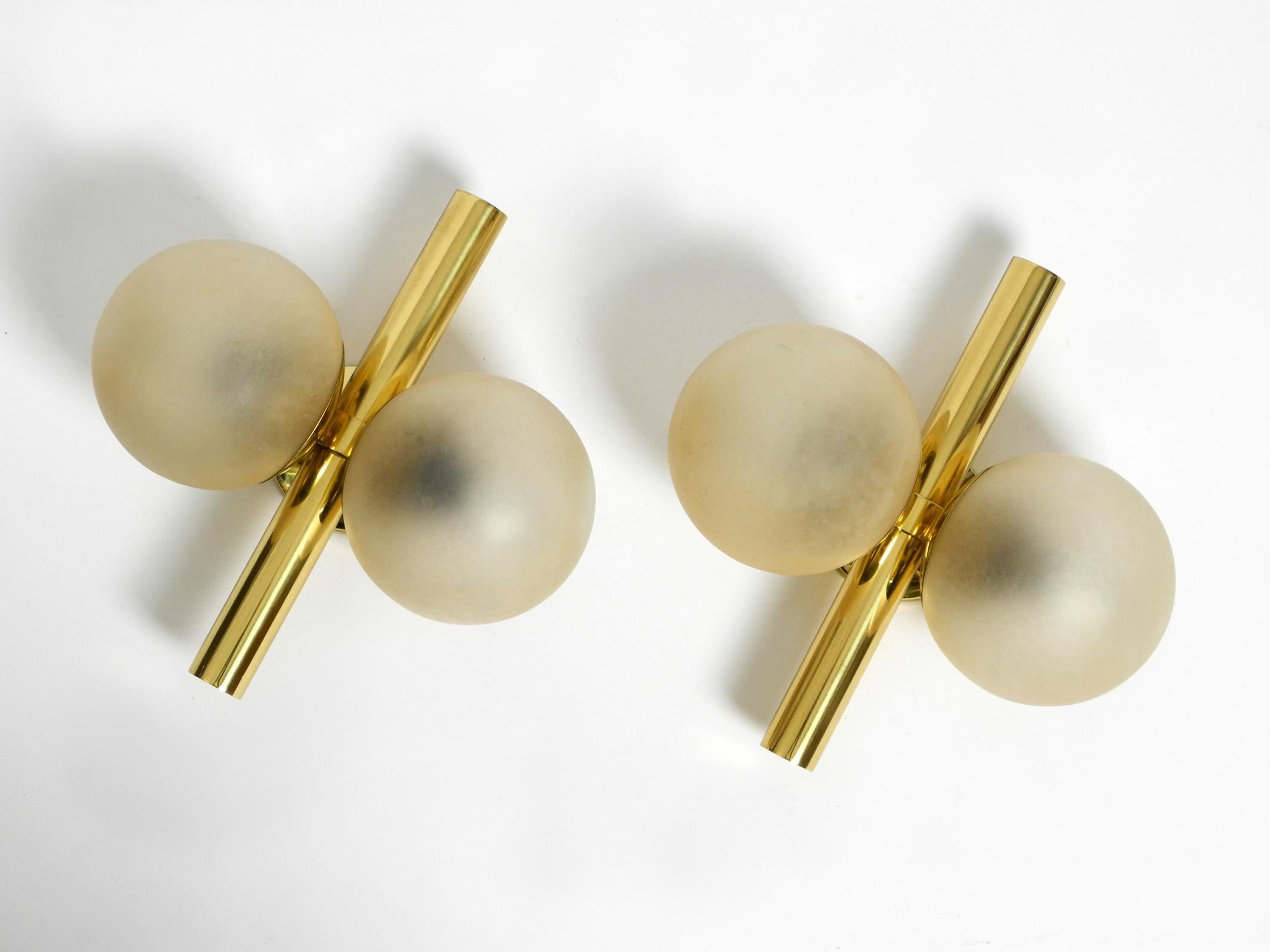 A pair of rare, beautiful Kaiser brass wall lamps with two gold-colored glass spheres.
Super sixties space age design. Two E14 sockets each for max. 40W each for glare-free light.
The original pull switches are still on both lamps.
Very good