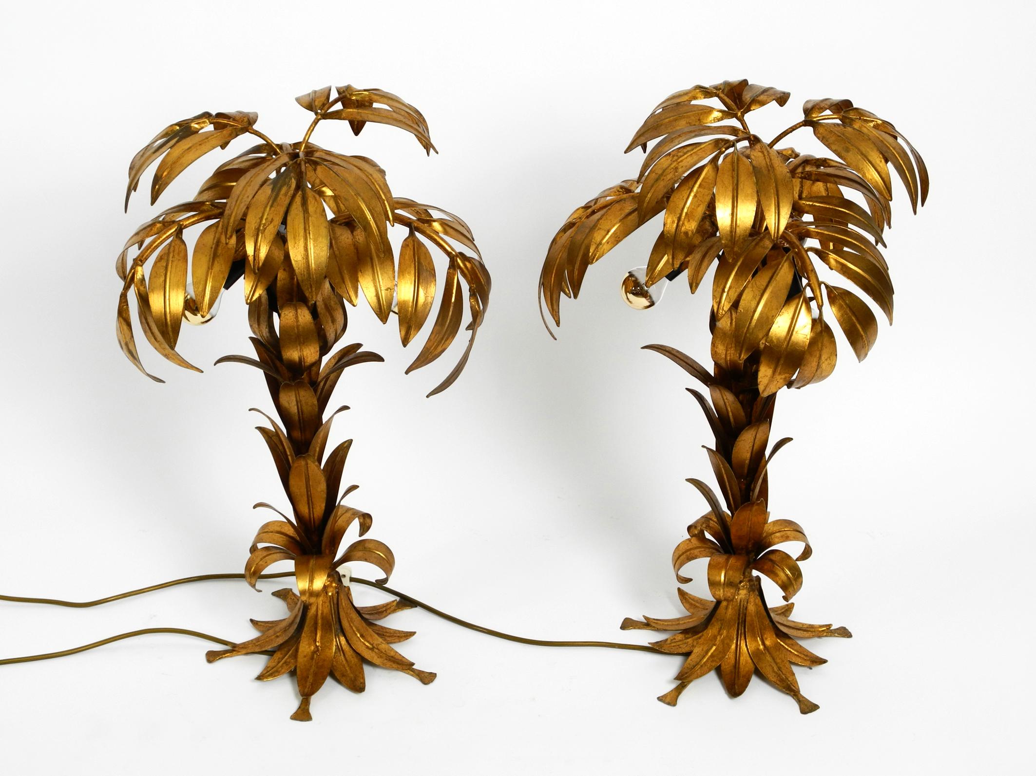 Pair of beautiful 1970s gold-plated metal palm table lamps by Hans Kögl.
Hans Kögl was a famous light and table designer.
 He worked with natural shapes like palm leaves and other plant shapes. 
His designs were produced in both countries Germany