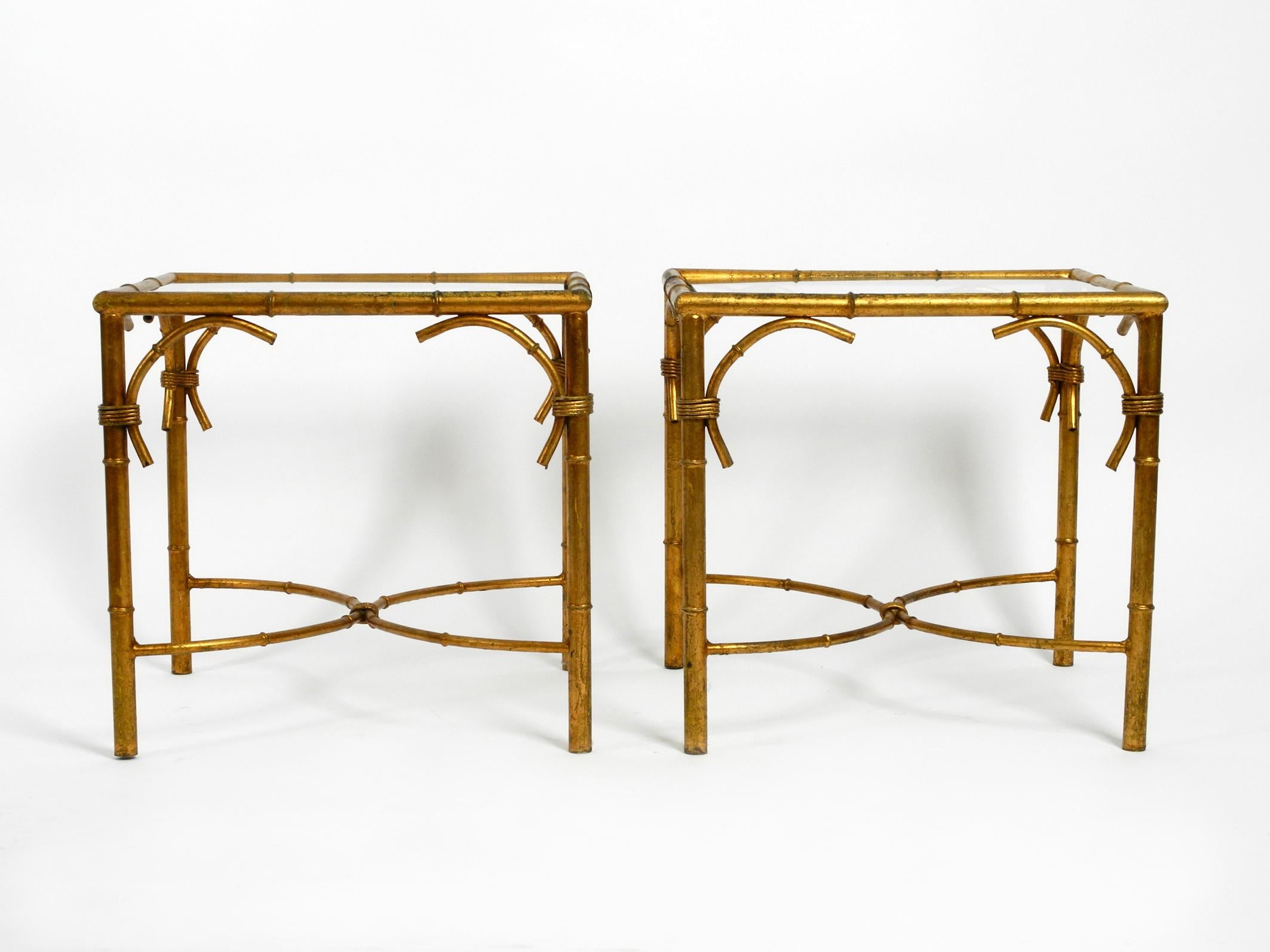 Pair of beautiful 1970s gold-plated metal glass side or bedside tables by Hans Kögl.
Hans Kögl was a famous light and table designer. 
He worked with natural shapes like palm leaves
and plant shapes. His designs were produced in both countries,