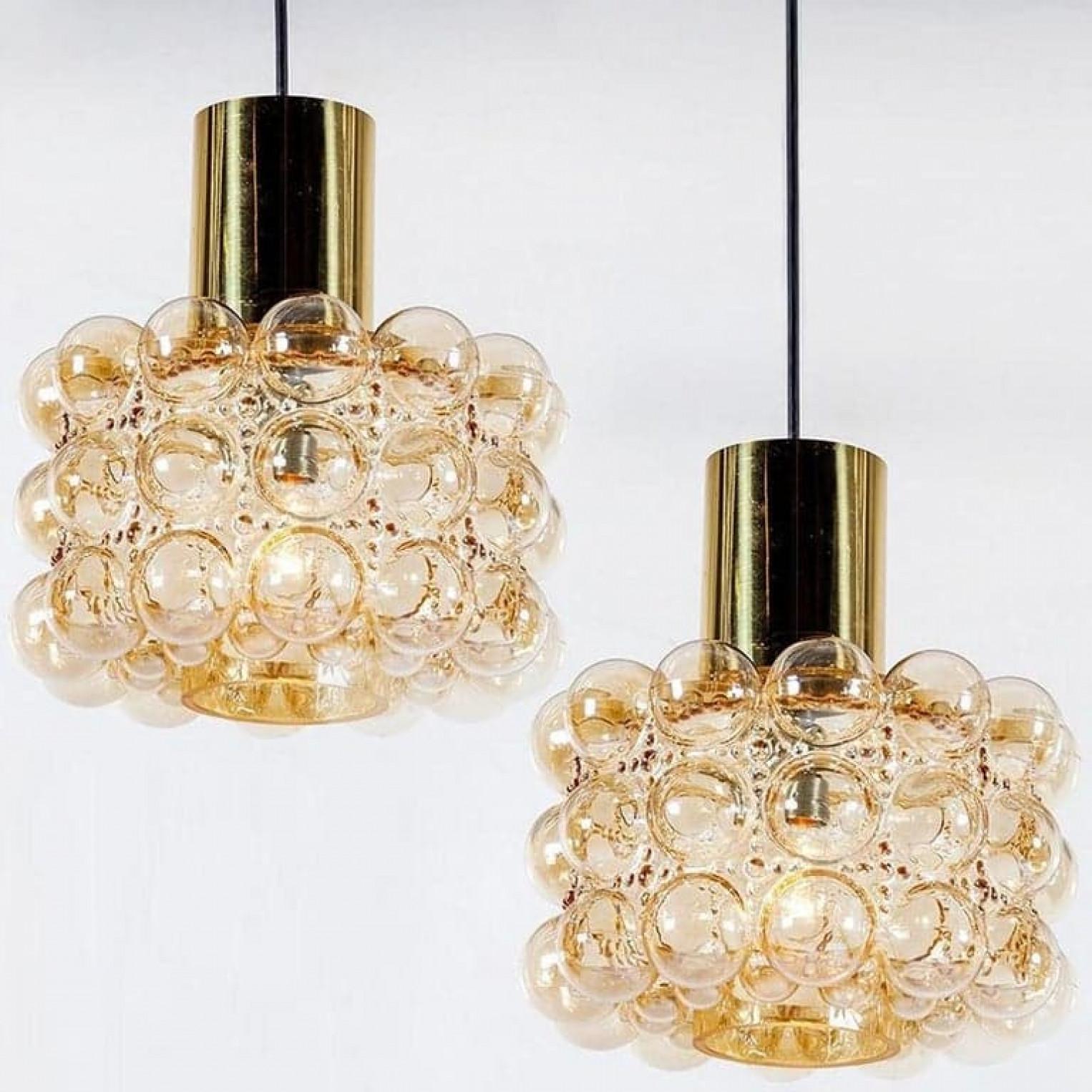 Pair of beautiful bubble glass chandeliers or pendant lights designed by Helena Tynell for Glashütte Limburg. A design Classic, the hand blown amber glass gives a wonderful warm glow.

The dimensions: Height 80 cm from ceiling, the diameter 30 cm.