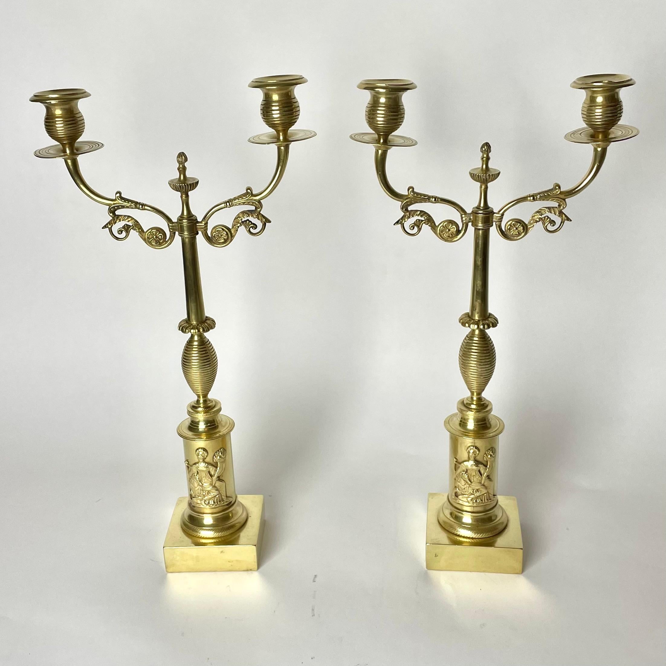 A beautiful pair of  Candelabras in brass. Made in Sweden during the 1820s.  Period design and decorations for Karl Johan, the Swedish Empire. 

Some height difference between the light arms due to age and use, but this does not affect the function