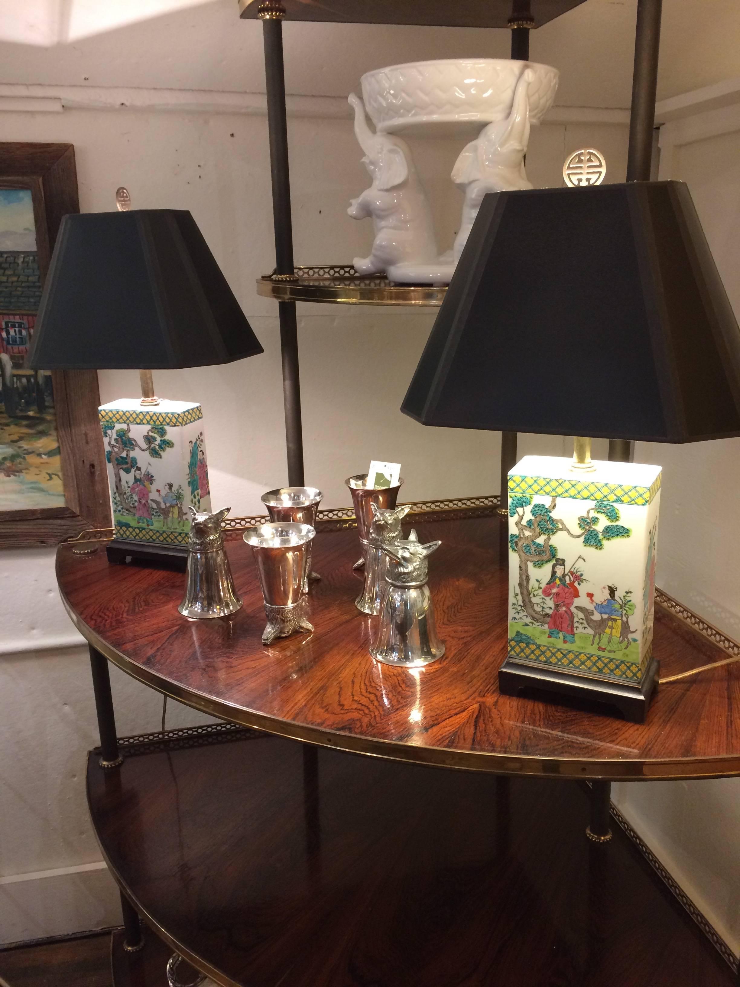 Two rectangular shaped porcelain hand-painted lamps having gorgeous figural scenes in a jewel toned color palette of soft green, pink and cream, on dark wood stands with custom black shades.
Porcelain part of lamp with bases measure 5.75 W x 3.25 D