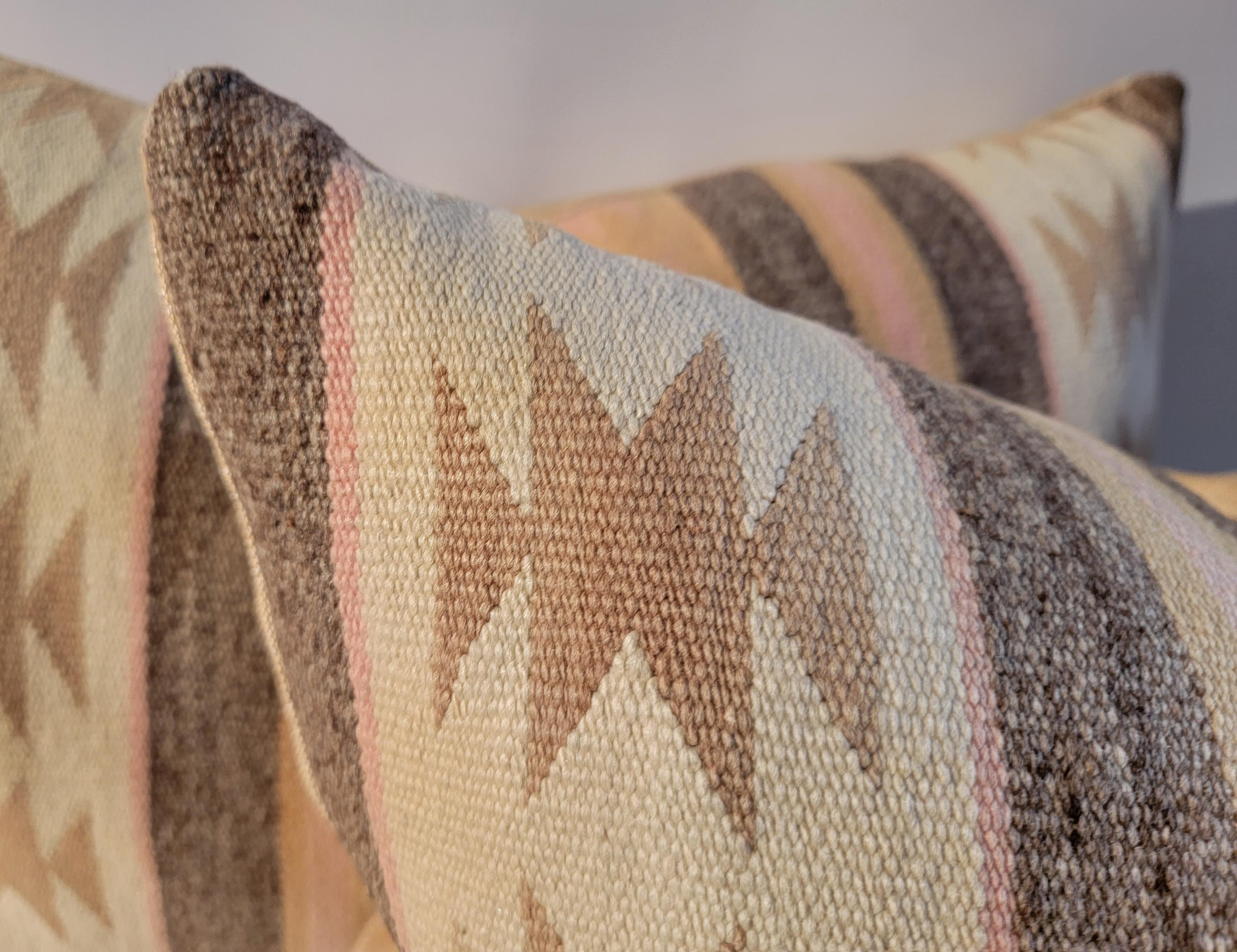 Pair of beautiful early geometric Navajo pillows. 
Soft colors of ivory, taupe, beige and pink. Down and feather inserts. Zippered casing.