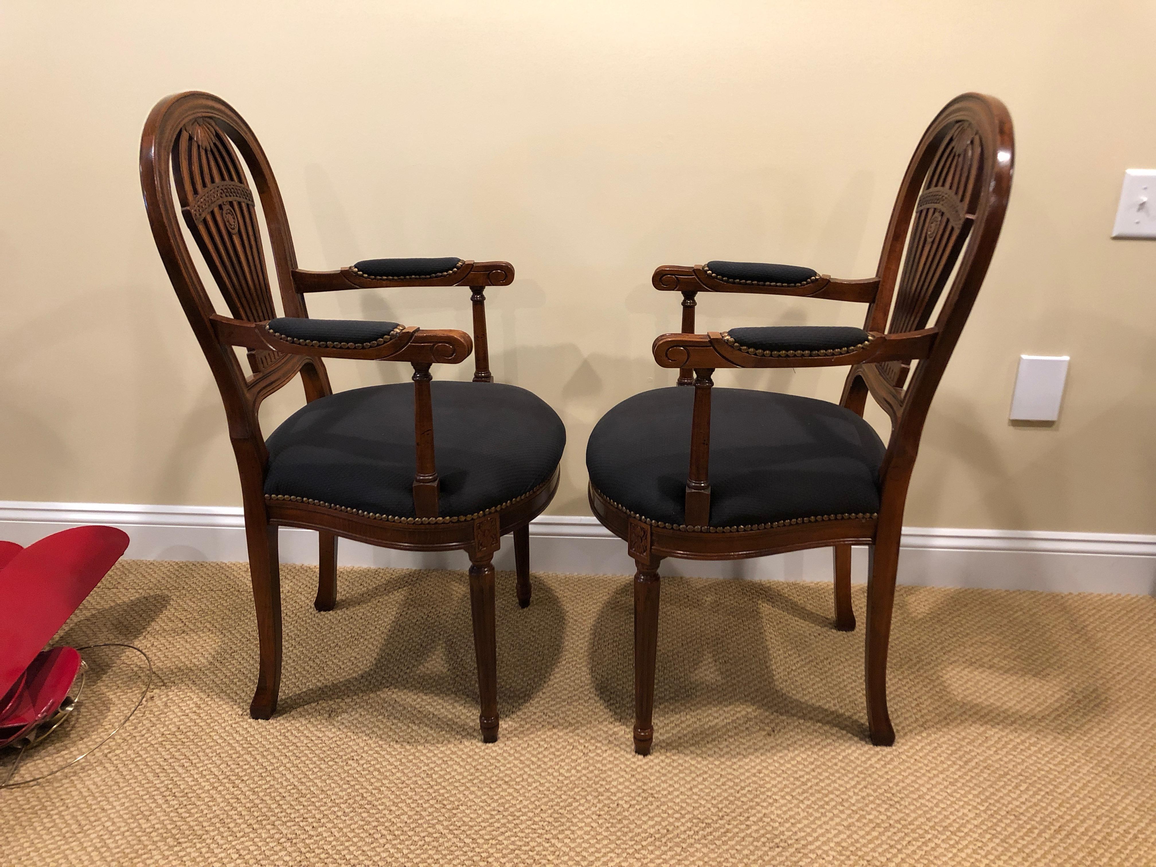 Lovely Italian armchairs having carved fruitwood frames and wonderful backs reminiscent of hot air balloons, with black cotton seats and armrests and handsome brass nailheads.
Measures: Arm height 27.25, seat depth 17.