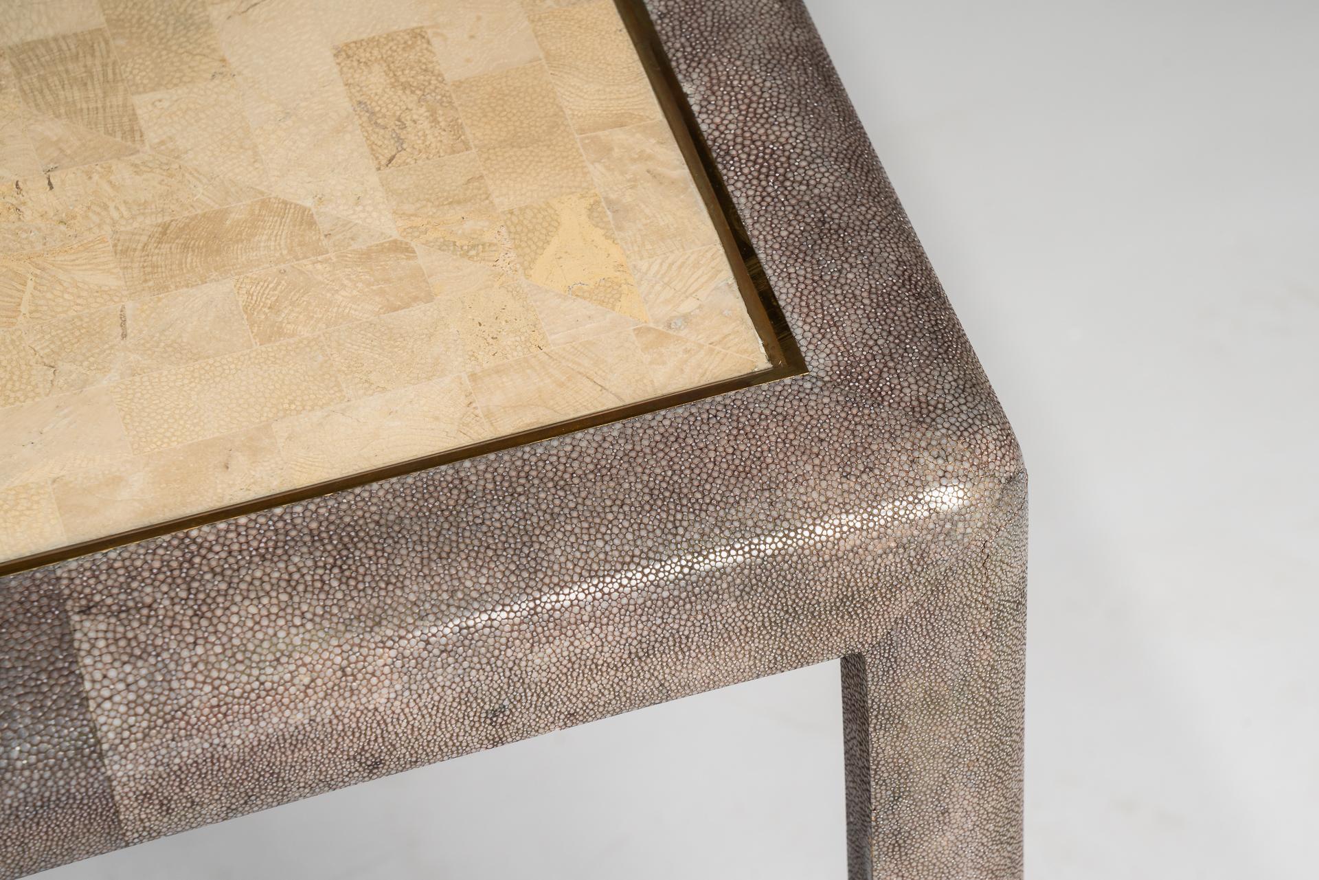 These very rare and modern pair of side tables by Maitland Smith are beautiful manufactured with the combination of the Galuchat / stingray leather which covers the legs and the sides of the table as well as a brass detail and the coral tabletop