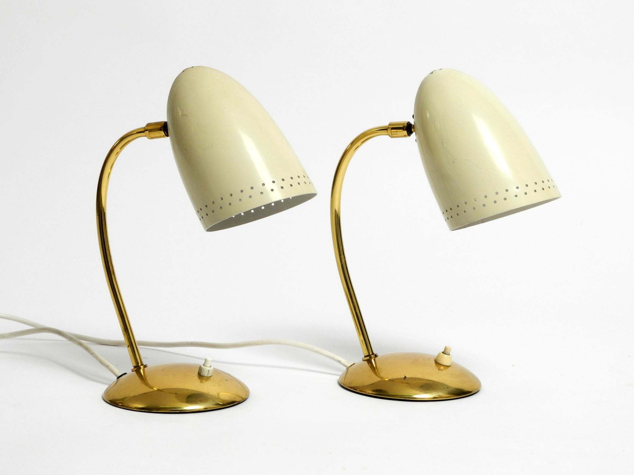 Pair of beautiful Mid-Century Modern brass table lamps with beige metal shades.
Great 1950s German Minimalist design in very good condition.
Lampshades are with small decorative holes on the rim.
Shades can be moved steplessly in all directions.