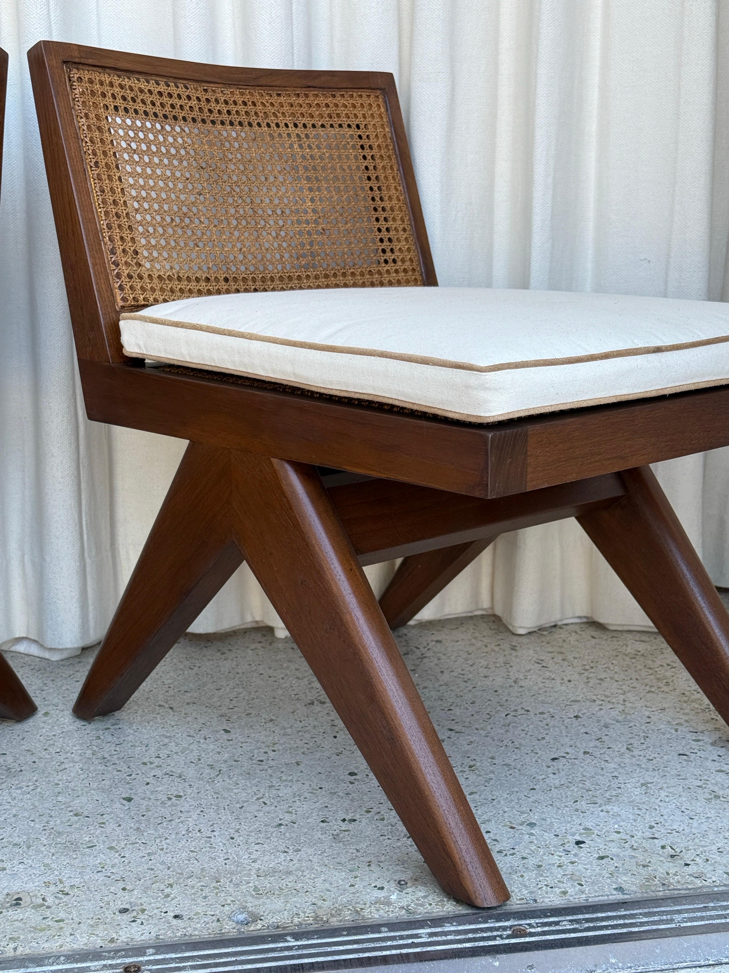 Ces belles chaises basses d'accent sont fabriquées en teck massif et en cannage à l'assise et au dossier.  Les oreillers illustrés sont inclus.  Un ton riche et sombre, lourd et très bien construit.  D'après un design de Pierre Jeanneret.