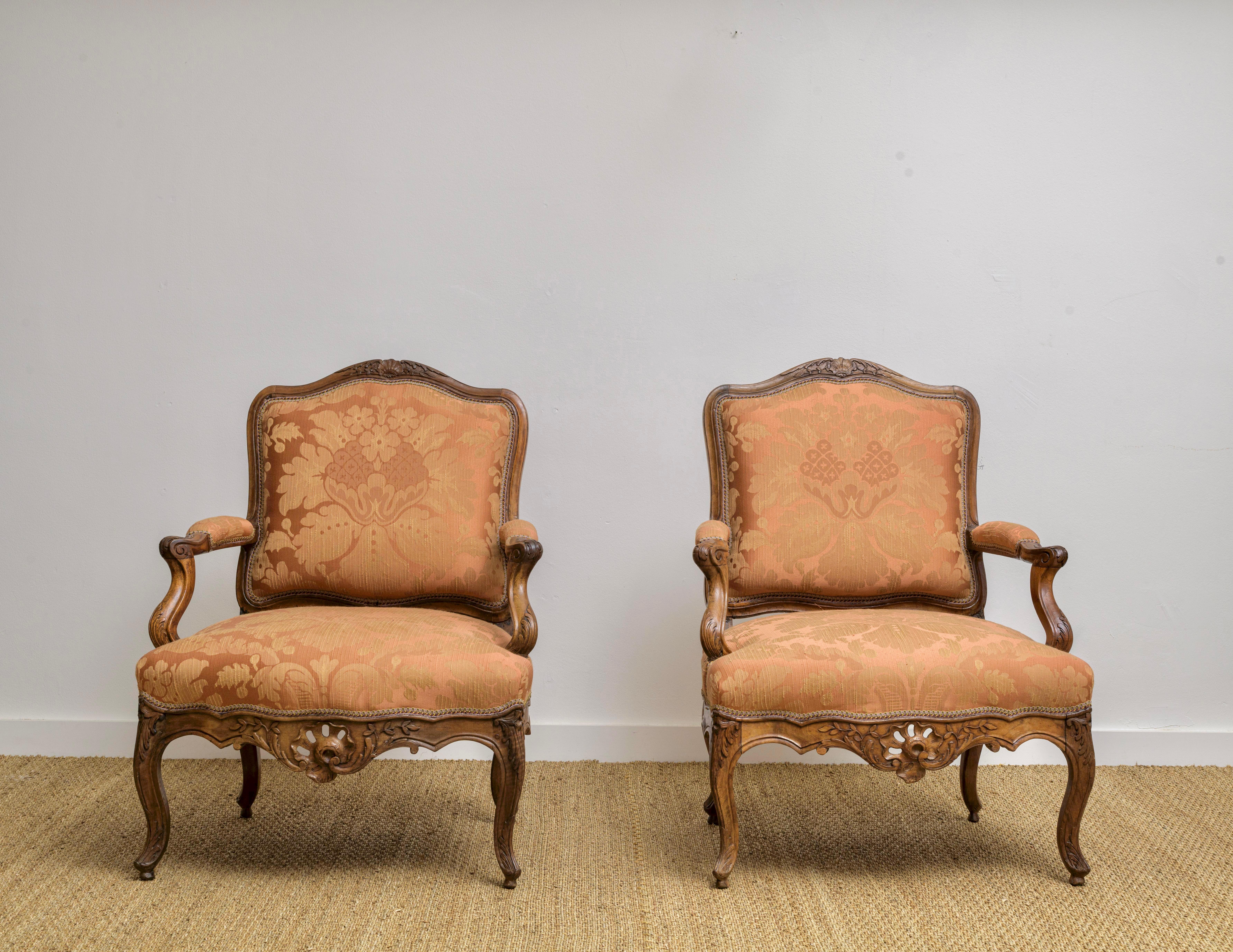 A Pair of Louis XV Carved Walnut Fauteuils a la Reine Chairs, Circa
1735.  Wonderful carving showing the rococo influence of the time.  Carving is a fine example showing great detail and the open fretwork on the apron.  Beautiful patina,  Recently