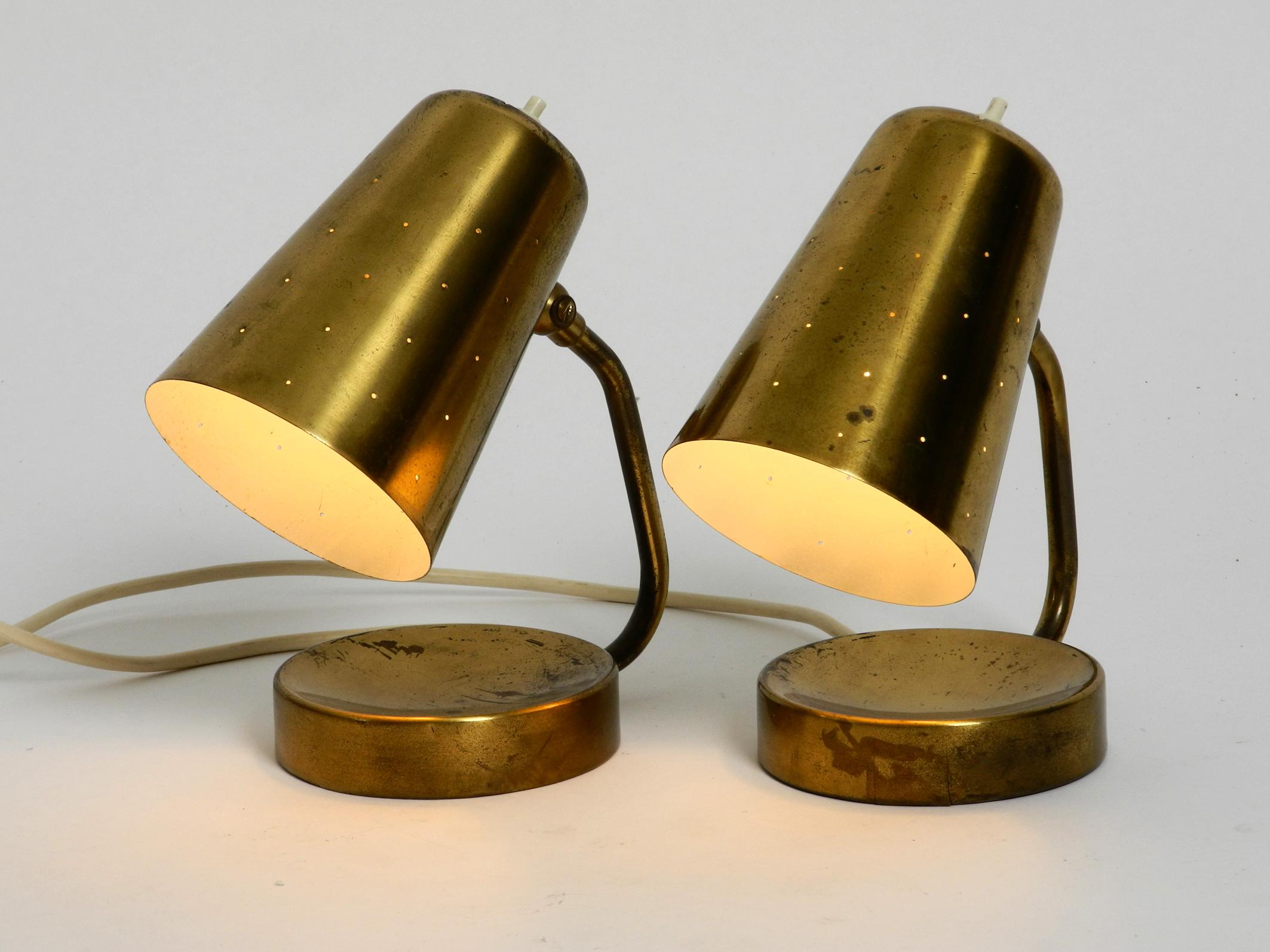 Pair of beautiful large midcentury brass table lamps.
The shades are steplessly adjustable.
Very classy 1950s design.
The shades have small holes, so it looks great when the light is shining through.
Good vintage condition. No damages, no dents