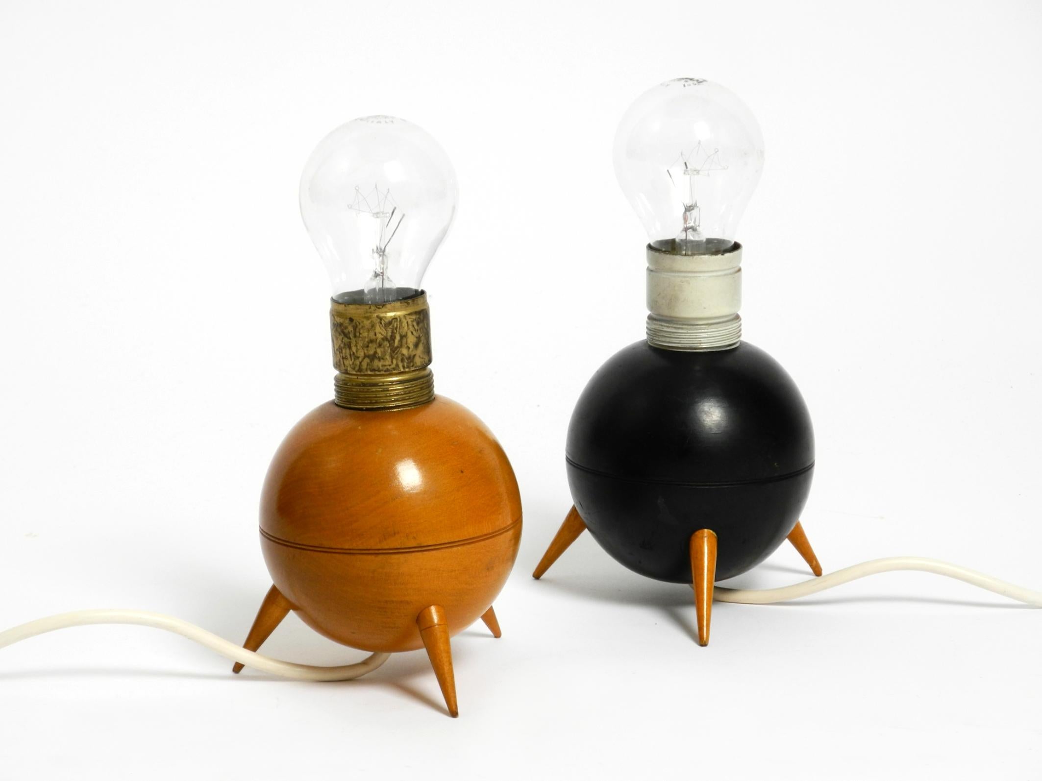 Une paire de jolies lampes de table en bois à trépied, sans abat-jour, de style moderne du milieu du siècle dernier.
L'une en bois naturel avec un vernis transparent, et l'autre peinte en noir.
Les deux surfaces sont d'origine.
Elles sont utilisées