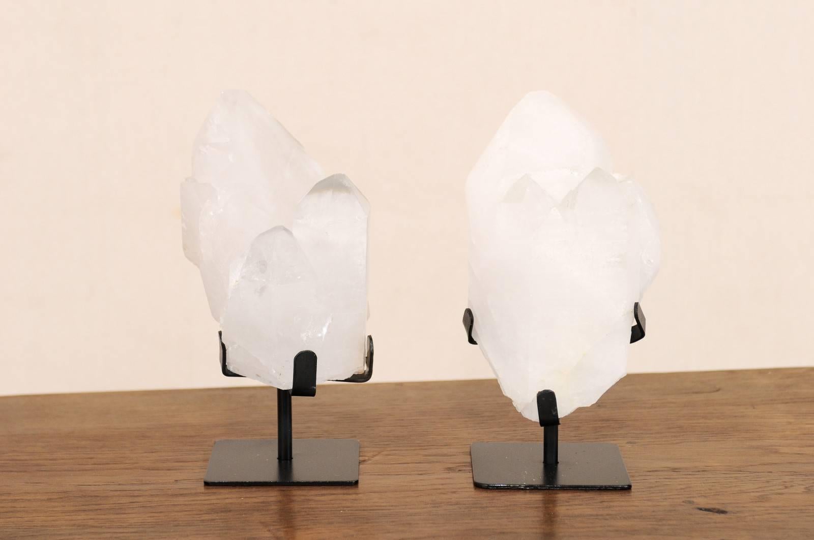 A pair of quartz crystals displayed on custom stands. This is a pair of natural quartz crystals from Uruguay have been presented on custom black metal stands. Quartz crystals have been valued throughout history, by nearly every civilization, for