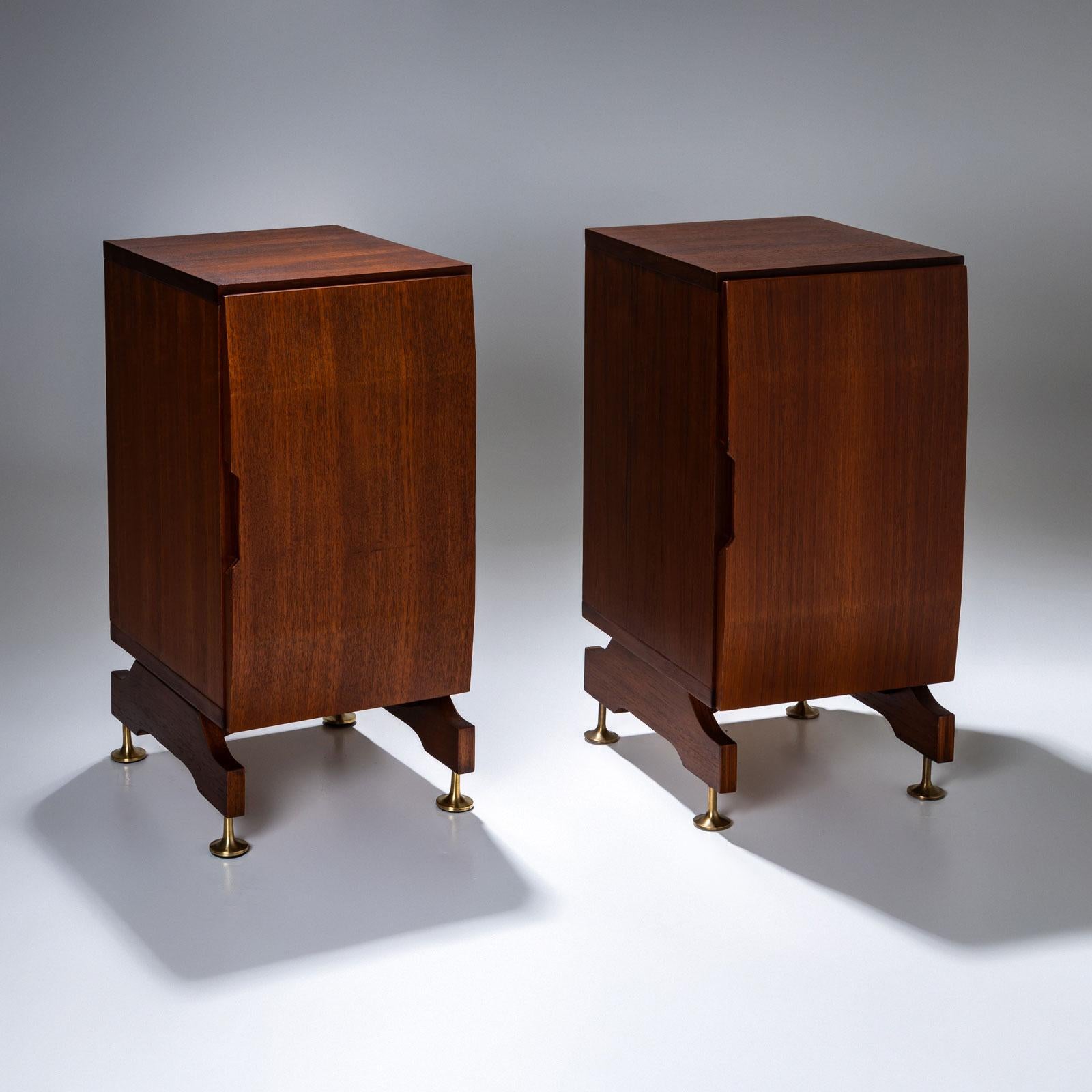 A pair of rectangular nightstands with a slightly convex door and conical brass legs. The nightstands have an interior shelf and plenty of storage space. The doors close with a magnet. The nightstands have been restored and are in ready-to-use