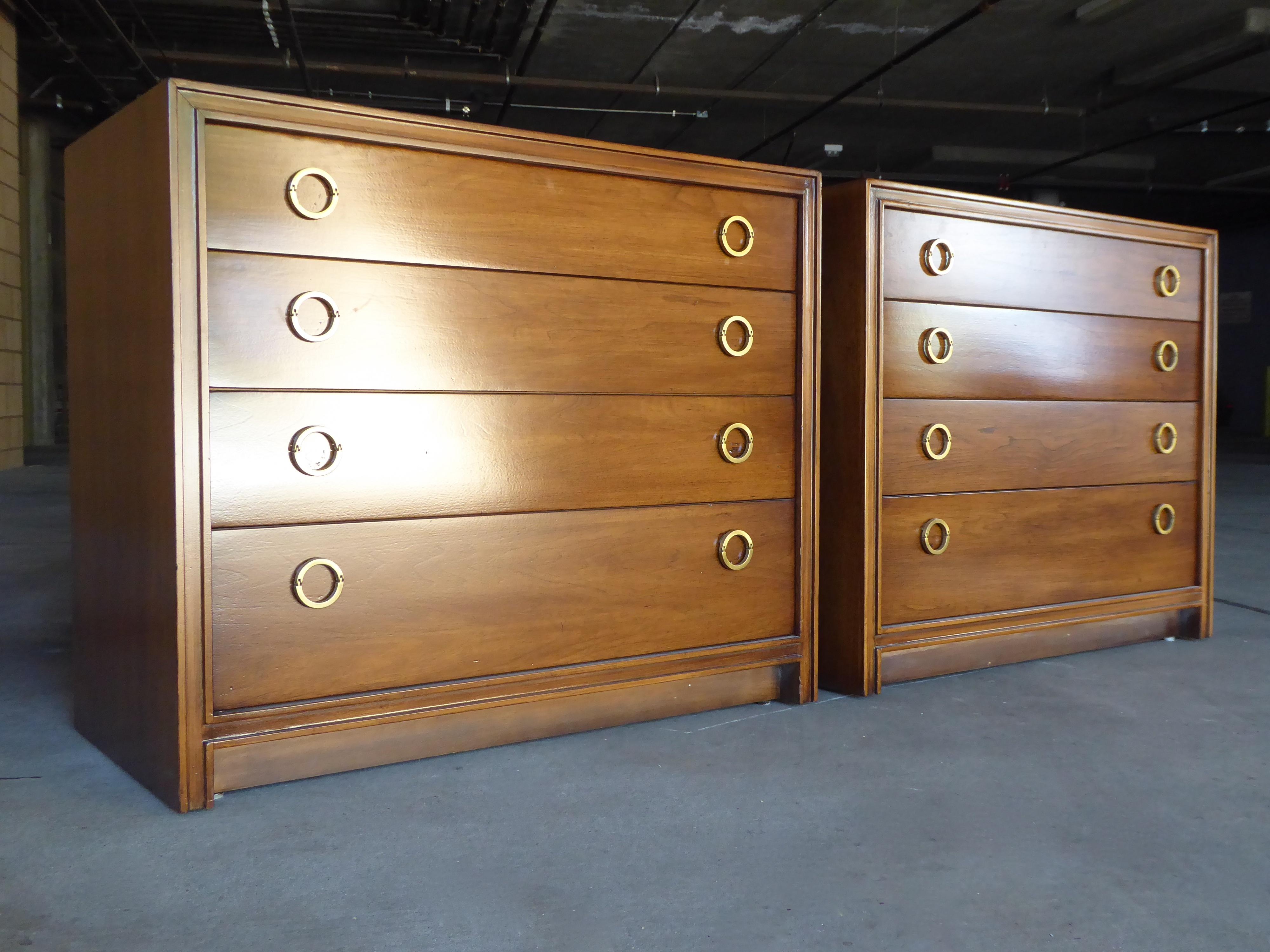 A pair of walnut four-drawer bedside chests made by Hickory Furniture Co., circa 1960s. The chests have been refinished and the brass hardware is original.