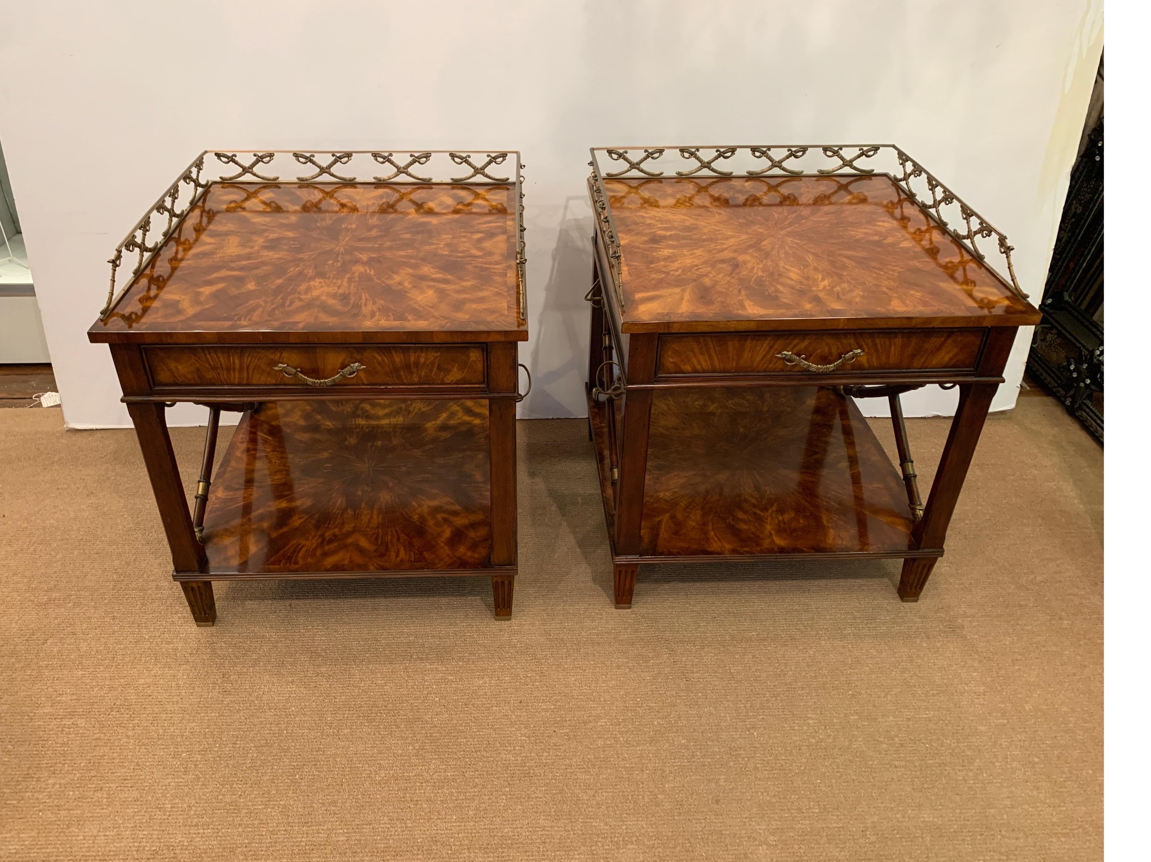 A pair of fame mahogany square side tables with cast brass gallery and mounts. The mounts with a sabre motif. The tables with upper drawer over an open shelf. Inside the drawer is an attached medal that reads 