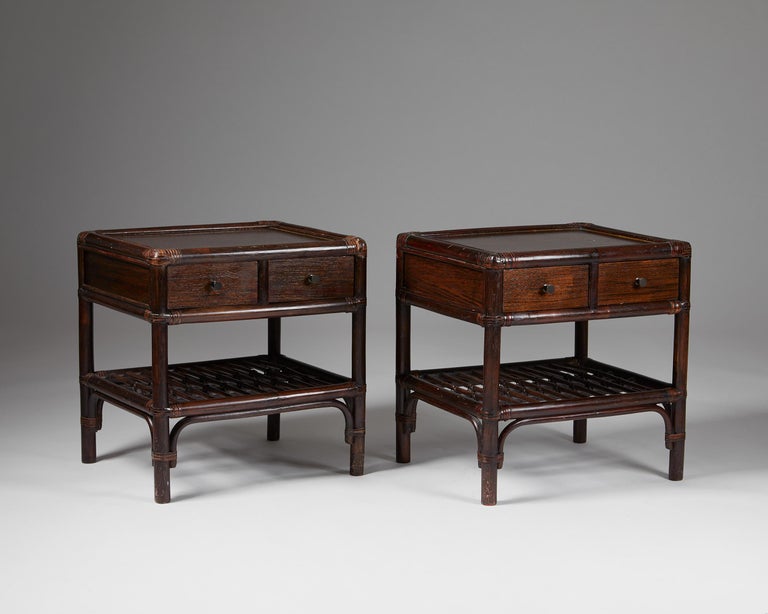 Pair of bedside tables, anonymous for DUX,
Sweden. 1960s.
Bamboo, cane and wood.

The colonial-style combination of stained bamboo, cane, and wood makes this Scandinavian bedside table design particularly interesting. The woven edges and metal