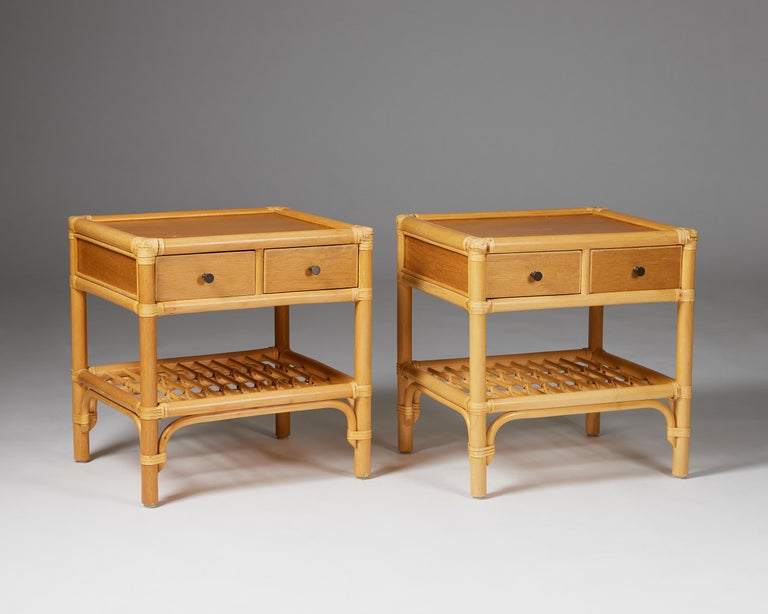Pair of bedside tables, anonymous for DUX,
Sweden, 1960s.
Cane, rattan, teak and metal.

The colonial-style combination of cane, rattan, and teak makes this Scandinavian bedside table design particularly interesting. The woven edges and metal