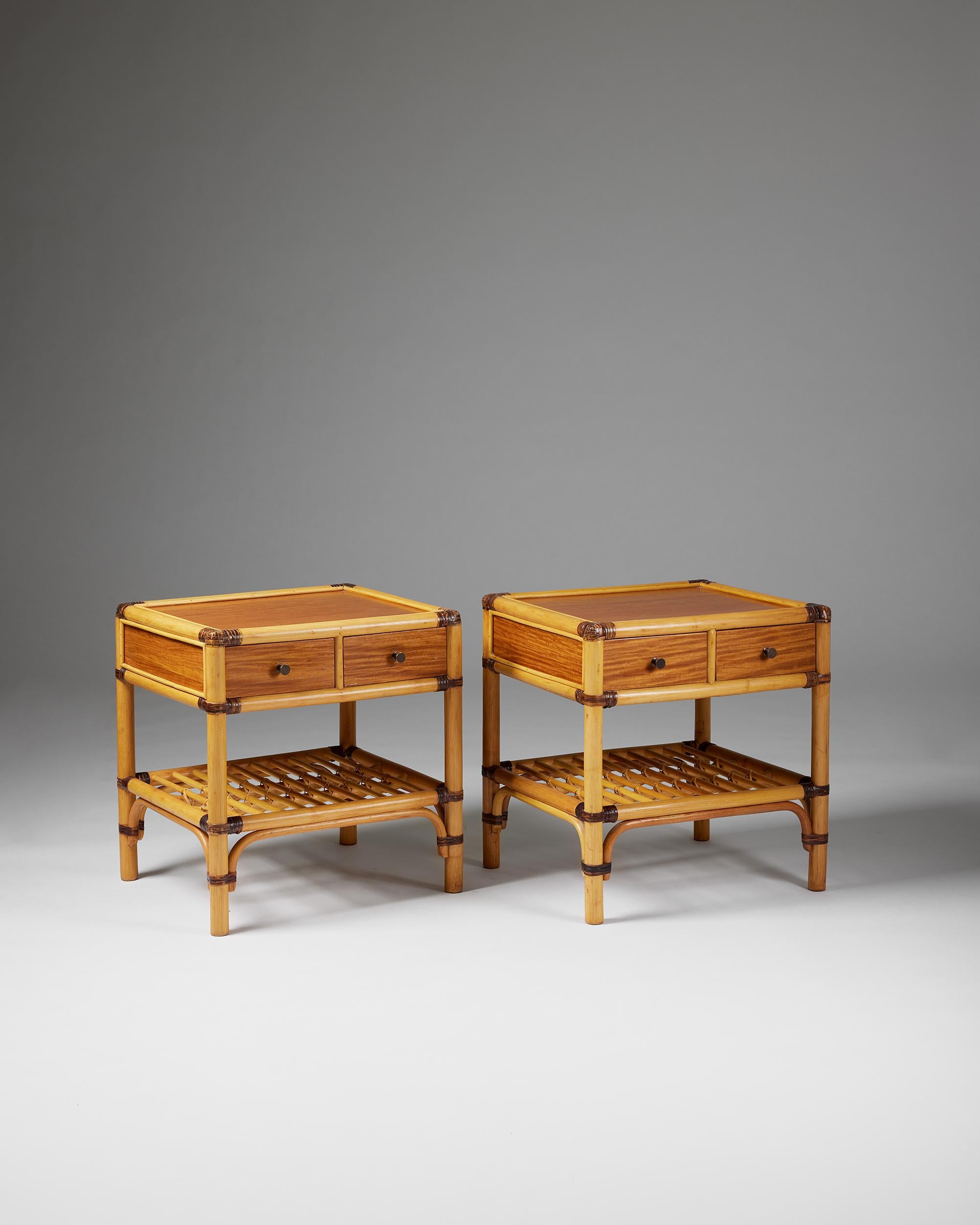 Pair of bedside tables, anonymous for DUX,
Sweden, 1960s.

Cane, rattan and teak.

The colonial-style combination of cane, rattan, and teak makes this Scandinavian bedside table design particularly interesting. The woven edges and metal handles