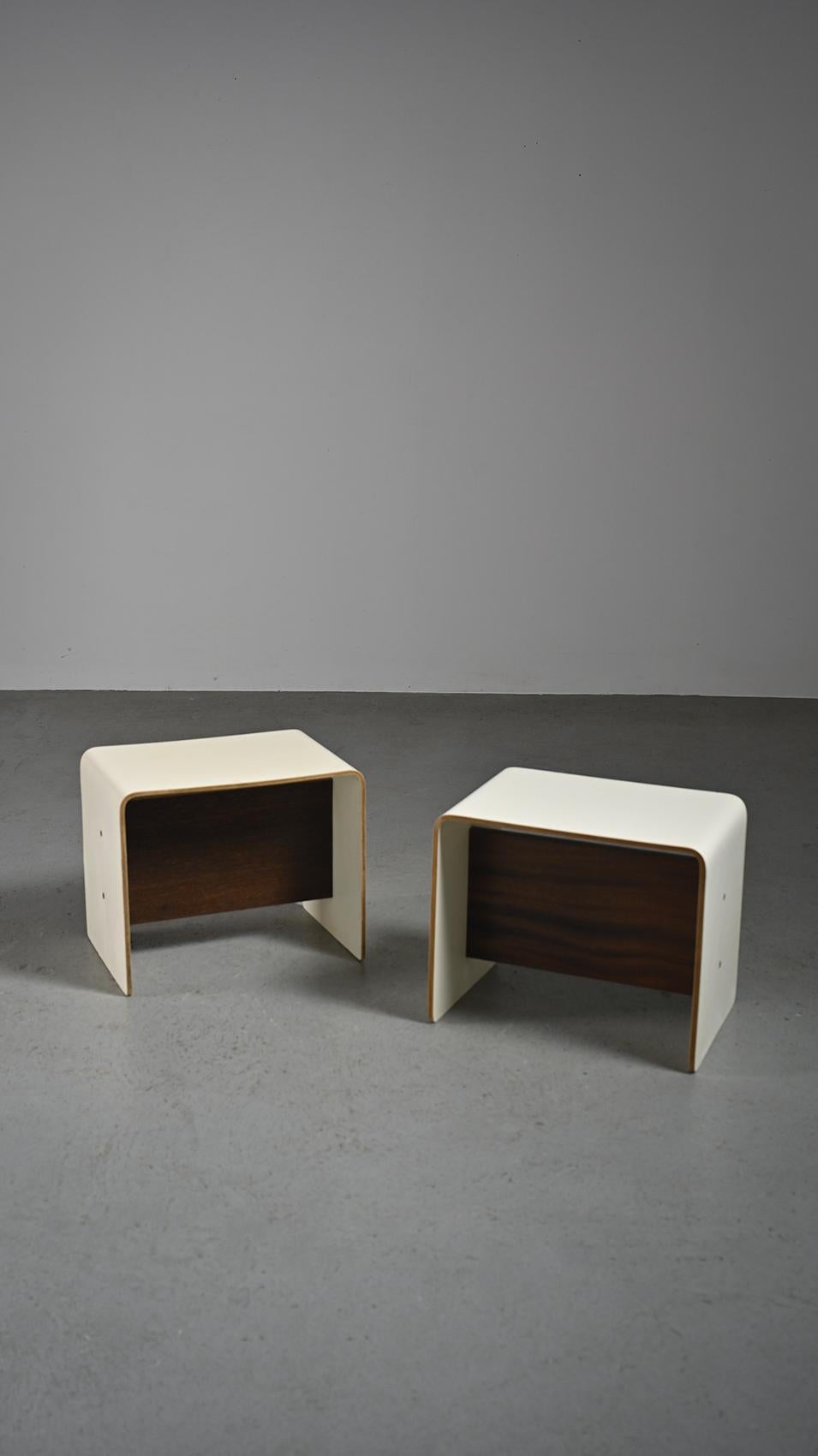 
Pair of nightstands with versatile design, serving as both nightstands and seats, they were conceived by the renowned French designer Pierre Guariche and was featured in both La Plagne and Bandol.

Crafted from U-shaped bent plywood and finished