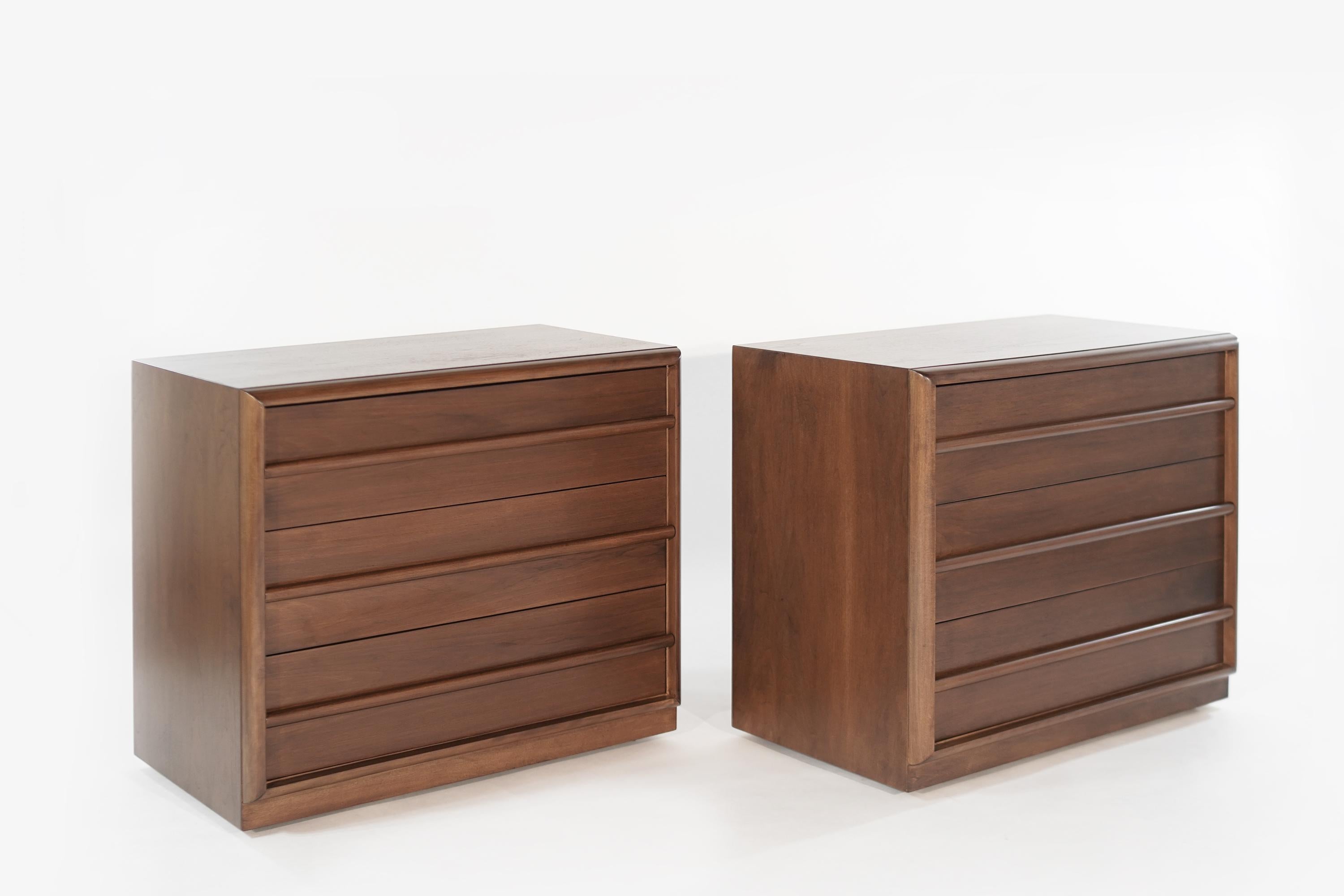 Rarely seen walnut bedside tables designed by T.H. Robsjohn-Gibbings for Widdicomb, circa 1950s. Each chest features three deep drawers offering ample storage space.