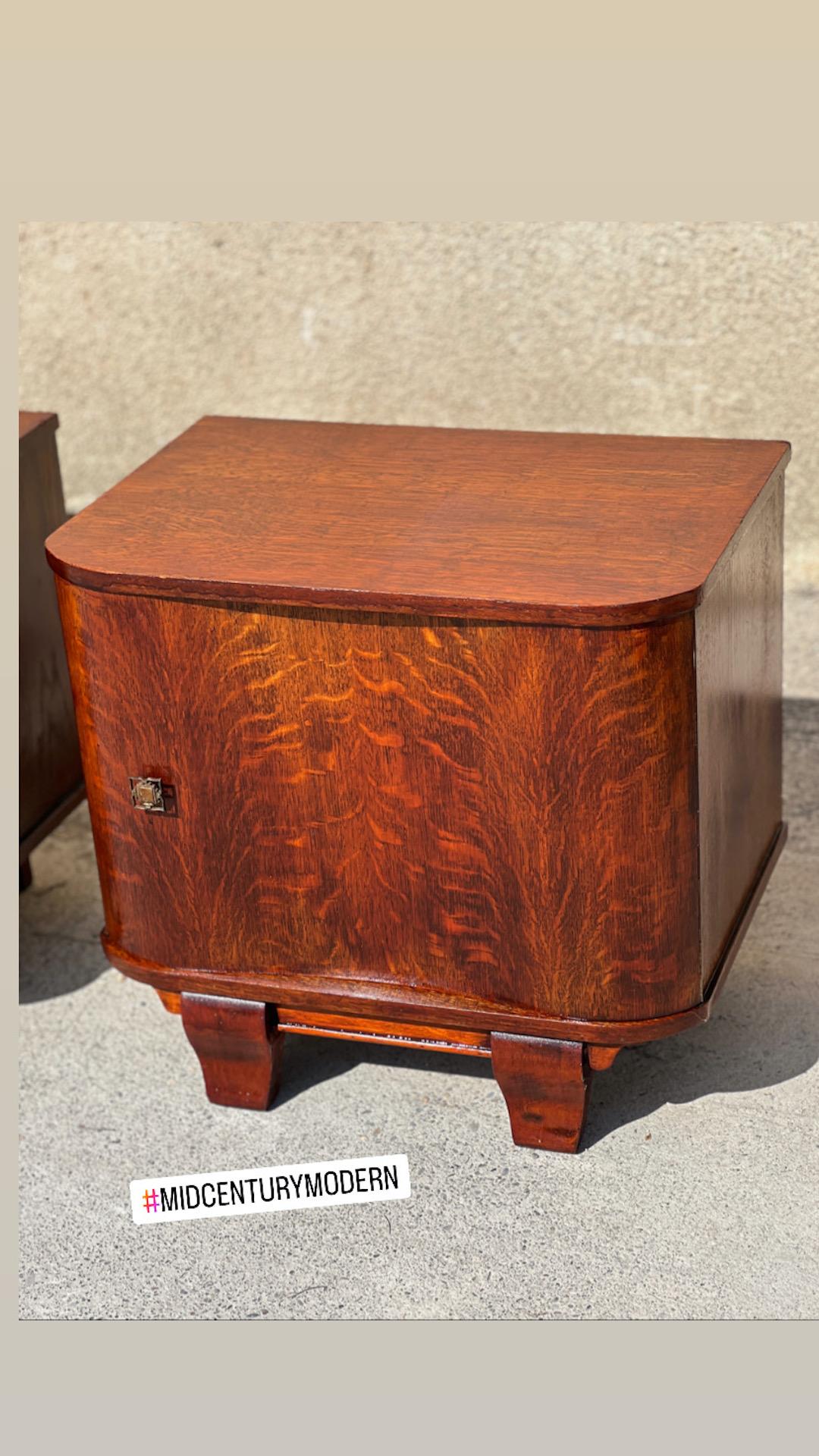 Pair of bedside tables French work 1940. Opening with wave-shaped doors, blackened metal entrance. Edges of the interior shelves finished with an inlaid frieze.