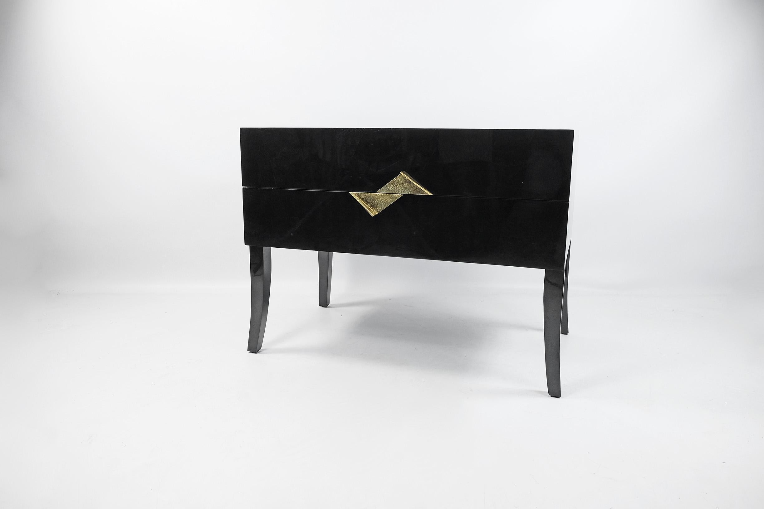 This rectangular bedside table has two drawers and it is made of a black shell marquetry.
The handles are in casted brass.
The interior has a dark wood veneer.
There are 4 feet in black shell with a curved design.

 
The dimensions of this