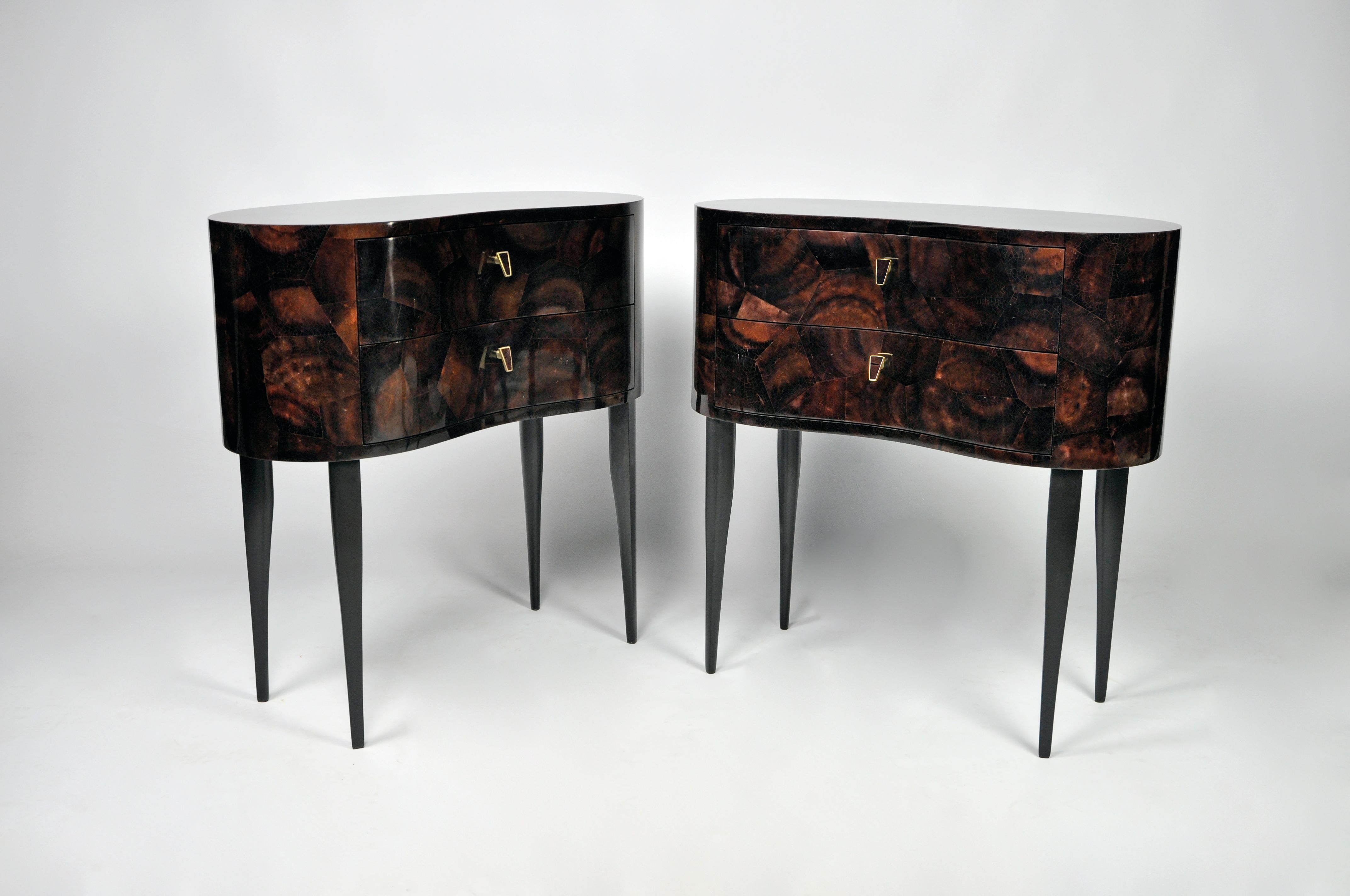 This bedside table is made of brown polished shell marquetry .
It has 2 drawers with brass and matching shell handles.
The legs are in black wood veneer.
The bean organic shape gives a very glamorous and sophisticated aspect to these tables.

The
