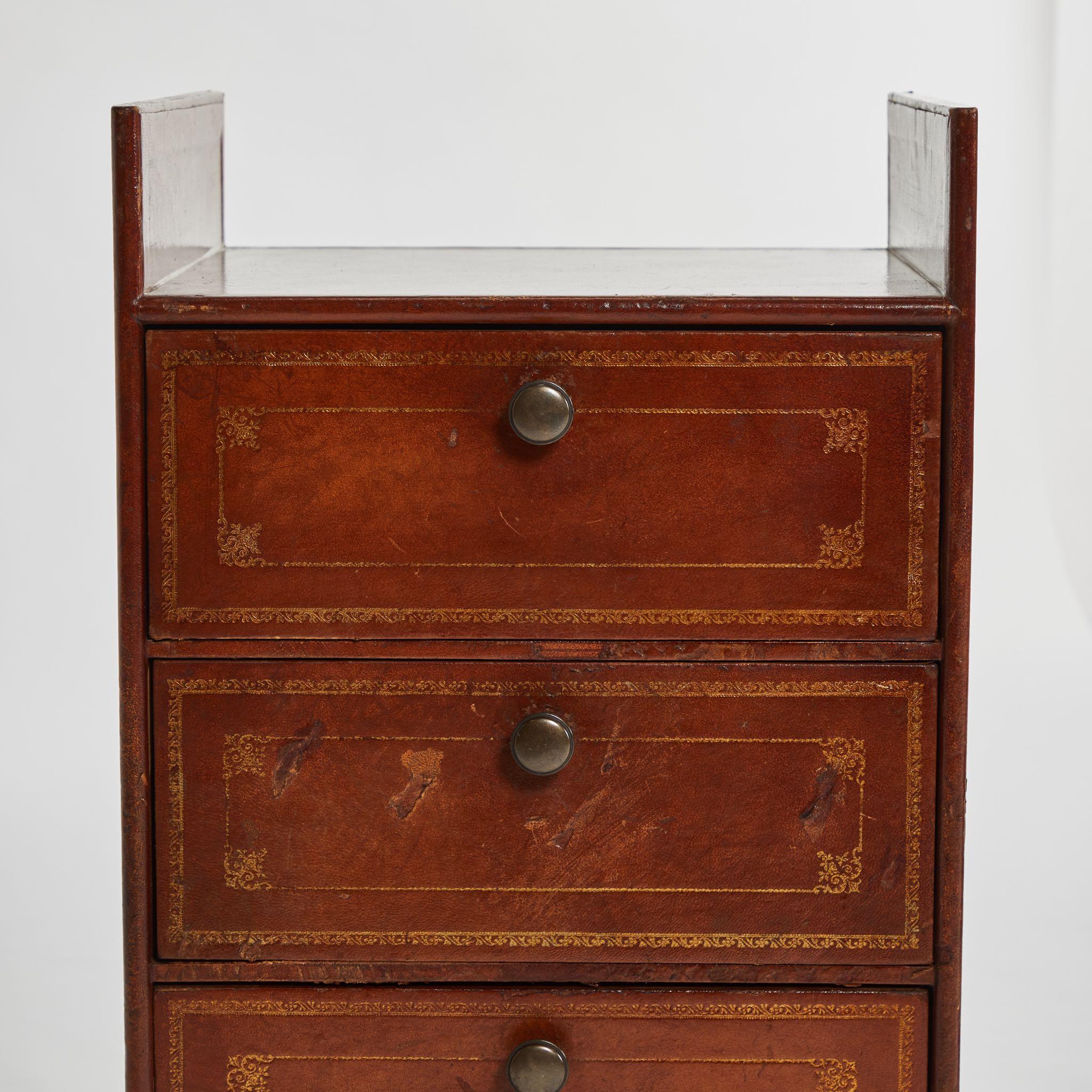 A pair of bedside tables in leather, originating in France, circa 1910.