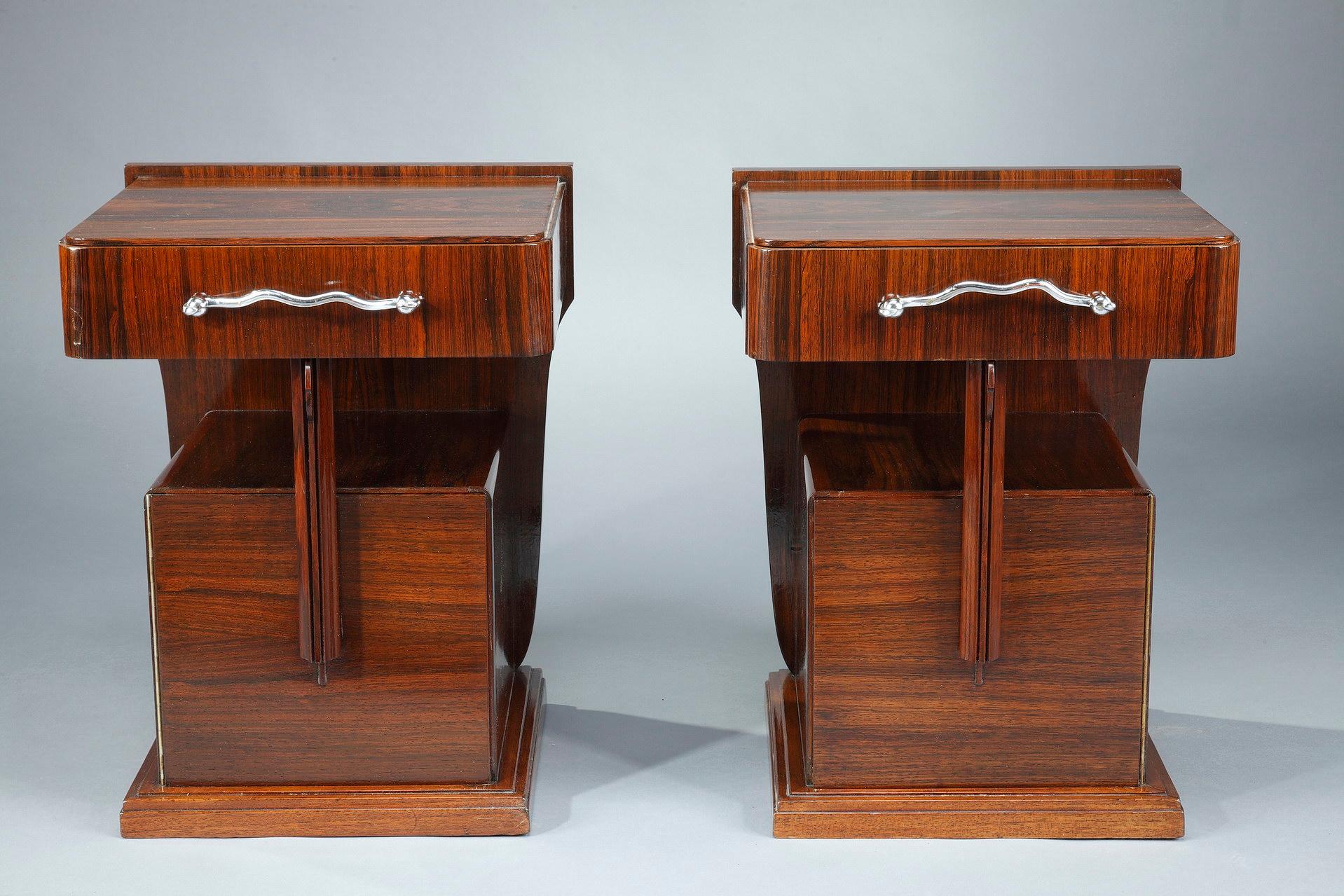 Pair of Art Deco bedside tables in Macassar ebony veneer, by the decorator Claude de Plasse. Each bedside table has a drawer opening with a chrome metal handle, and a small square cupboard. 

The Macassar ebony is a wood alternating black and