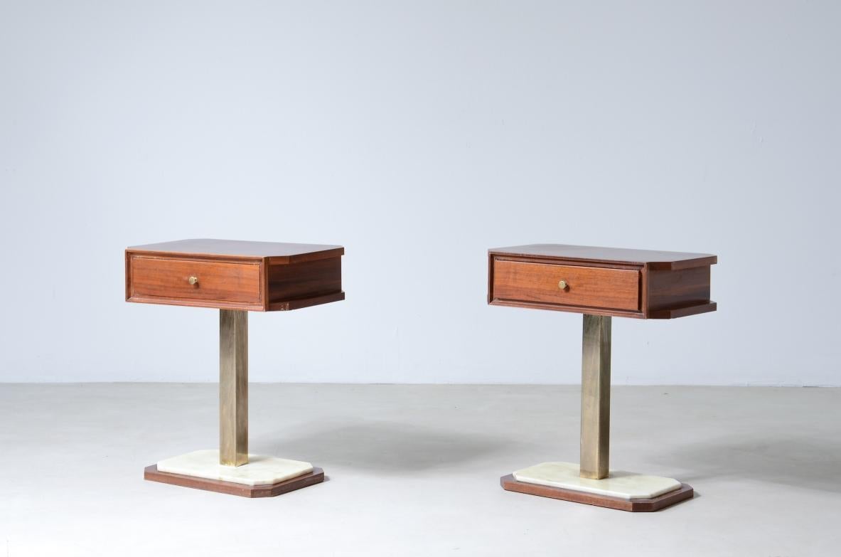 COD-2484
Pair of bedside tables in walnut with marble base and brass column uprights.

Italian manufacture around 1960s.

48x30xh55