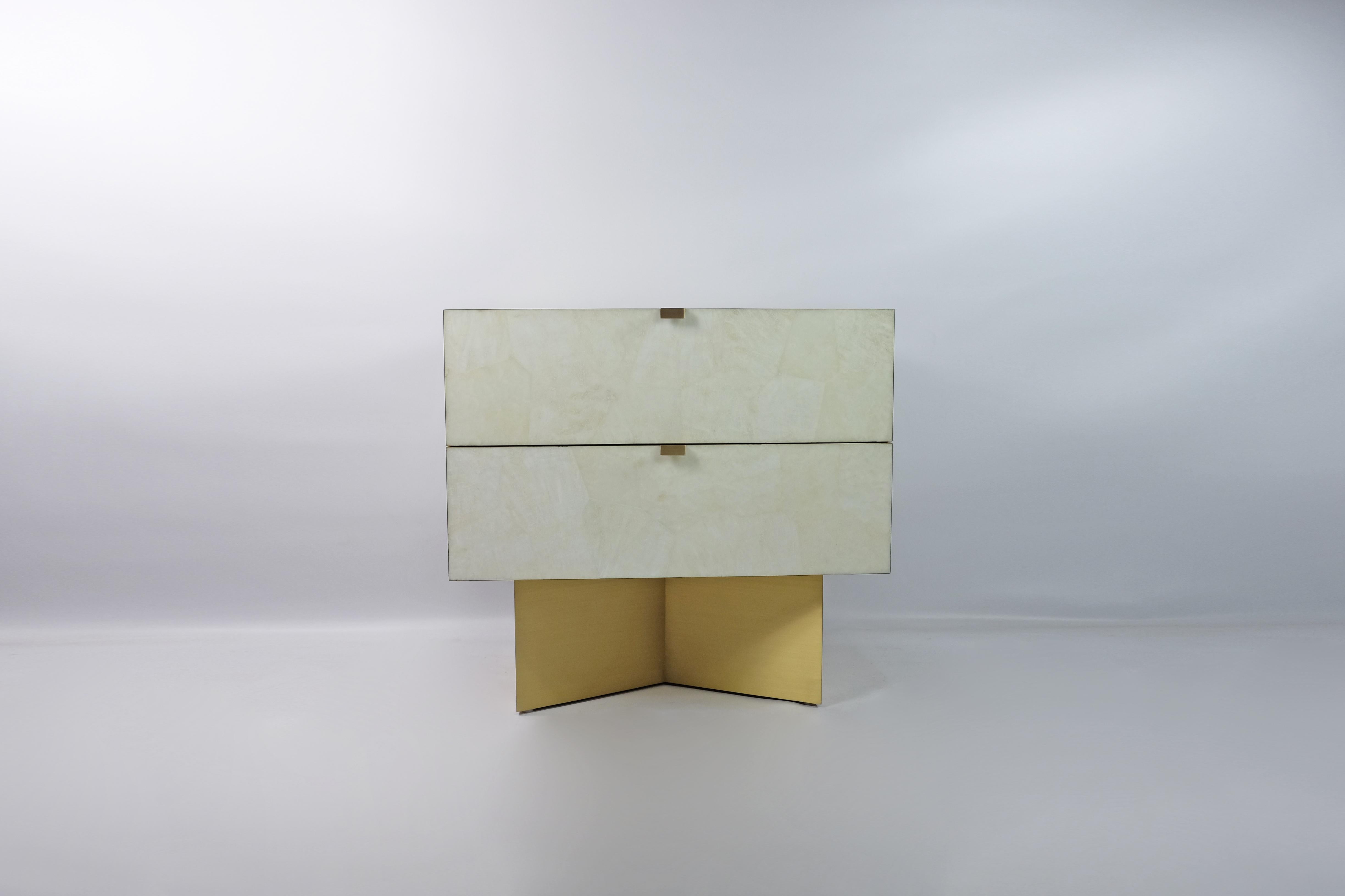 This pair of night stand tables is made of rock crystal marquetry with brass trims.
 
The interior of the drawers is made with light oak veneer.
The knobs and the base are in brass with a brushed finish. (It can be made with an aged brass