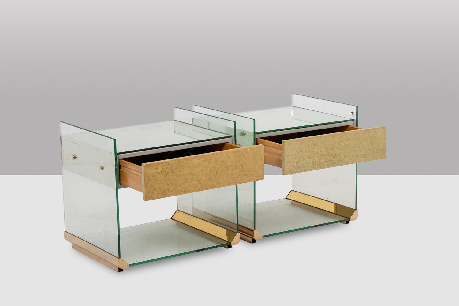 Coppia di comodini o divanetti in ottone, vetro e specchio, con apertura a 1 cassetto in legno nella parte anteriore.

Opera italiana realizzata negli anni '1970.

Dimensioni: H. H. 47,5 x L. 40 cm.

Riferimento : LS6566387U