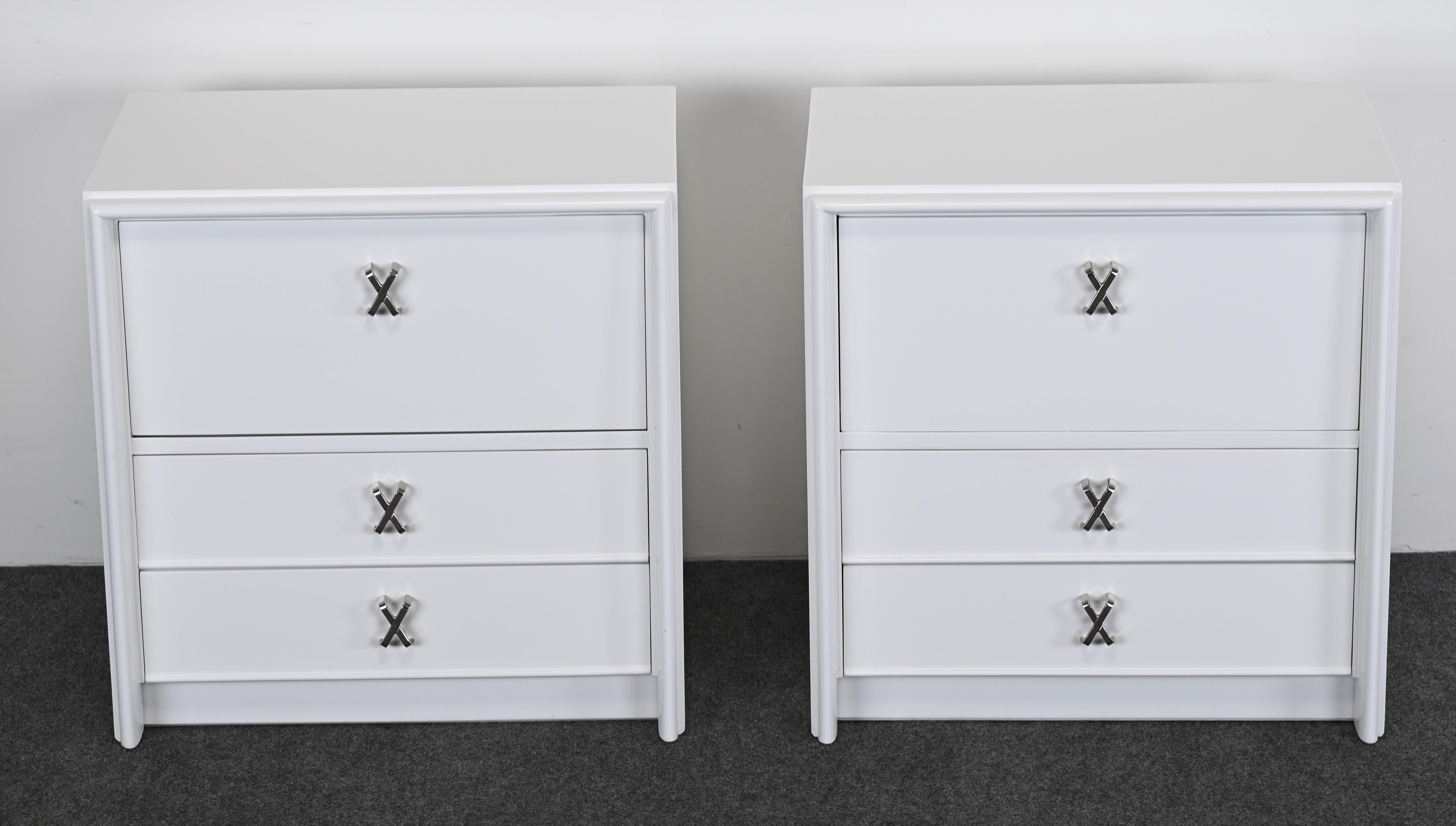Pair of nightstands or bedside tables with original silver metal X-pulls and white high gloss Italian finish by Paul Frankl. Newly refinished in high-quality Italian finish by Alternative Furnishings Inc.  Labeled inside drawer Johnson Furniture Co,