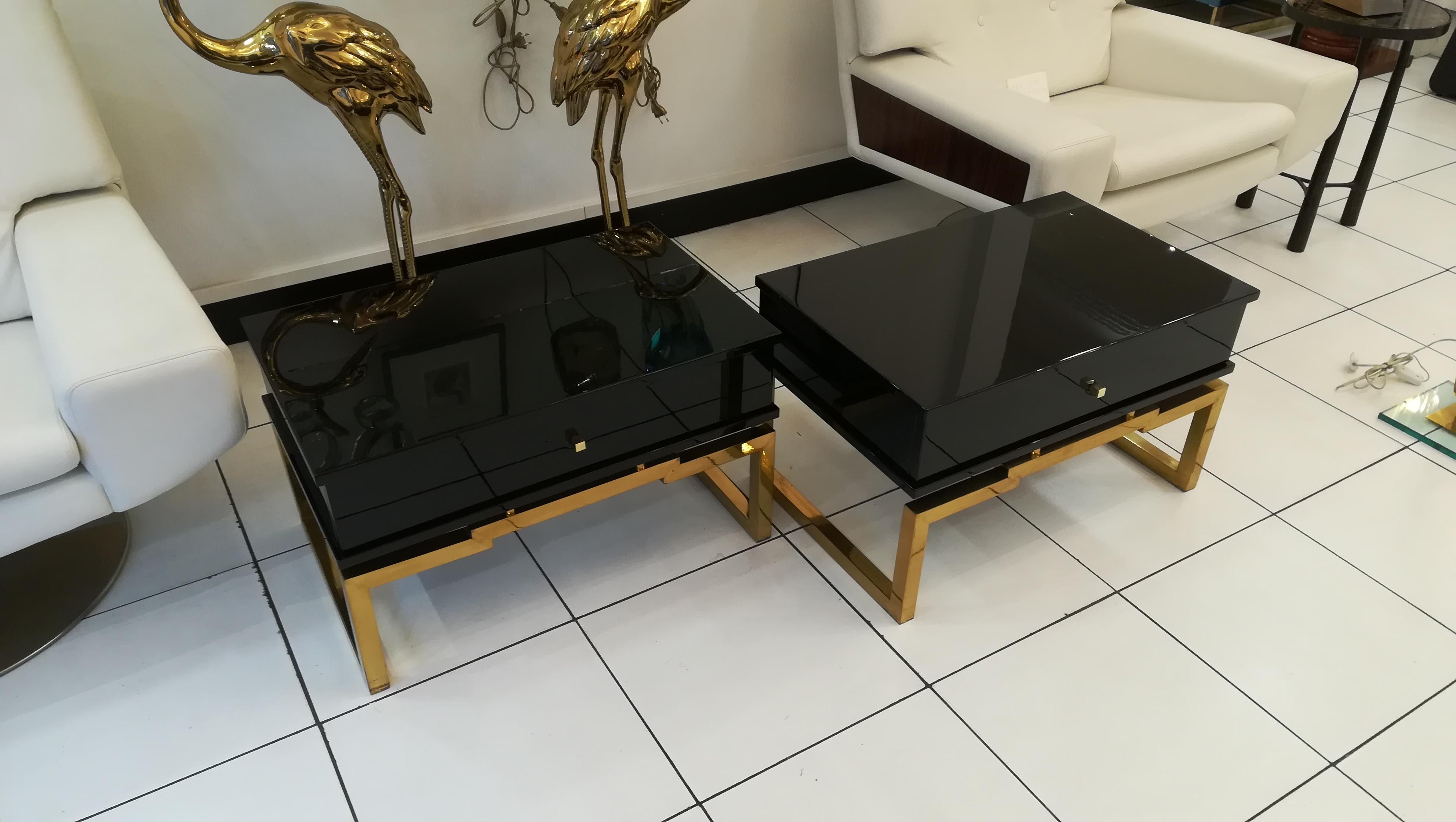 Pair of bedsides or end tables in lacquered wood, brass feet, circa 1970.