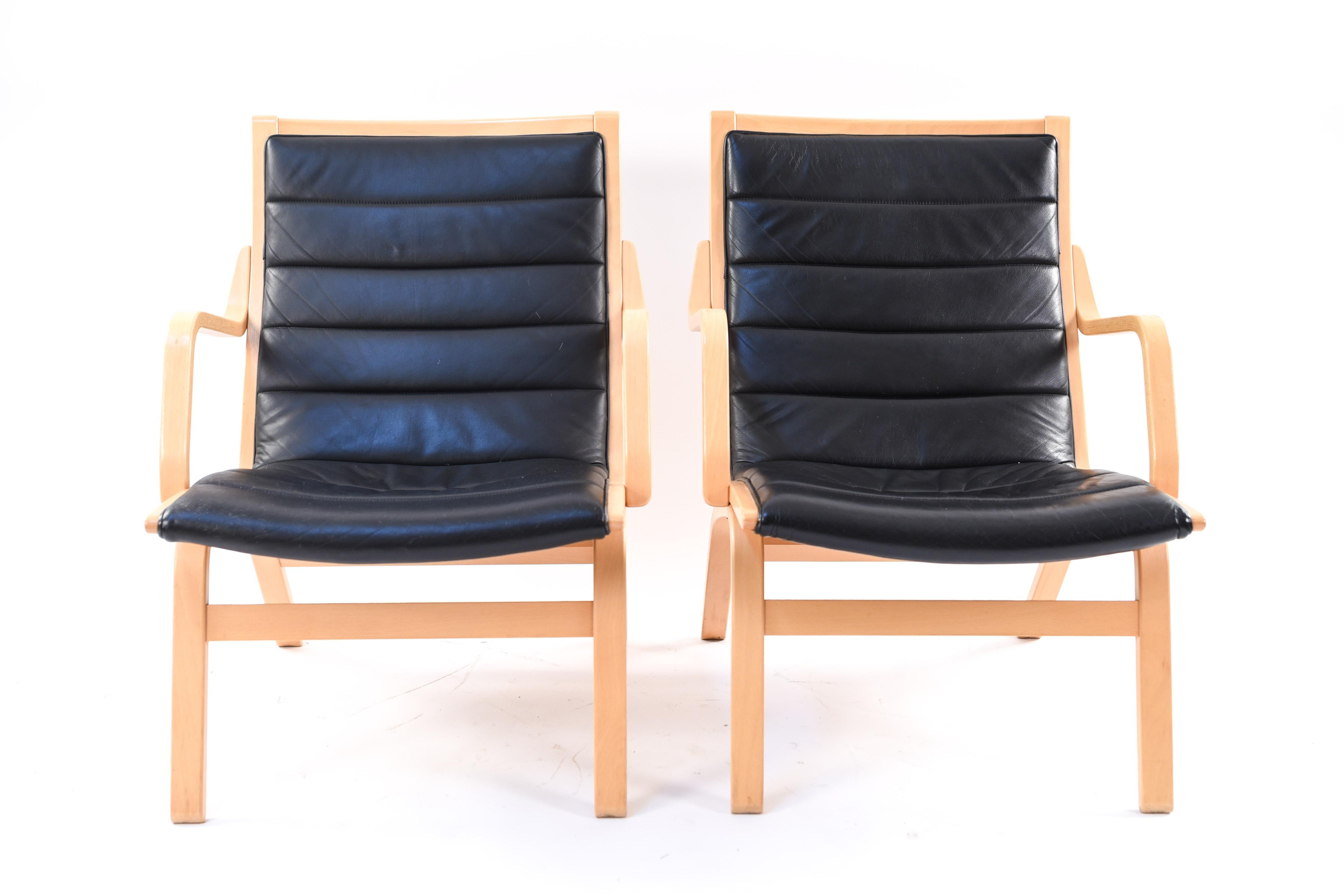 A pair of Danish midcentury lounge chairs by Farstrup, circa 1970s. These chairs have bentwood frames of beech and leather upholstery for a sleek, smooth appearance.