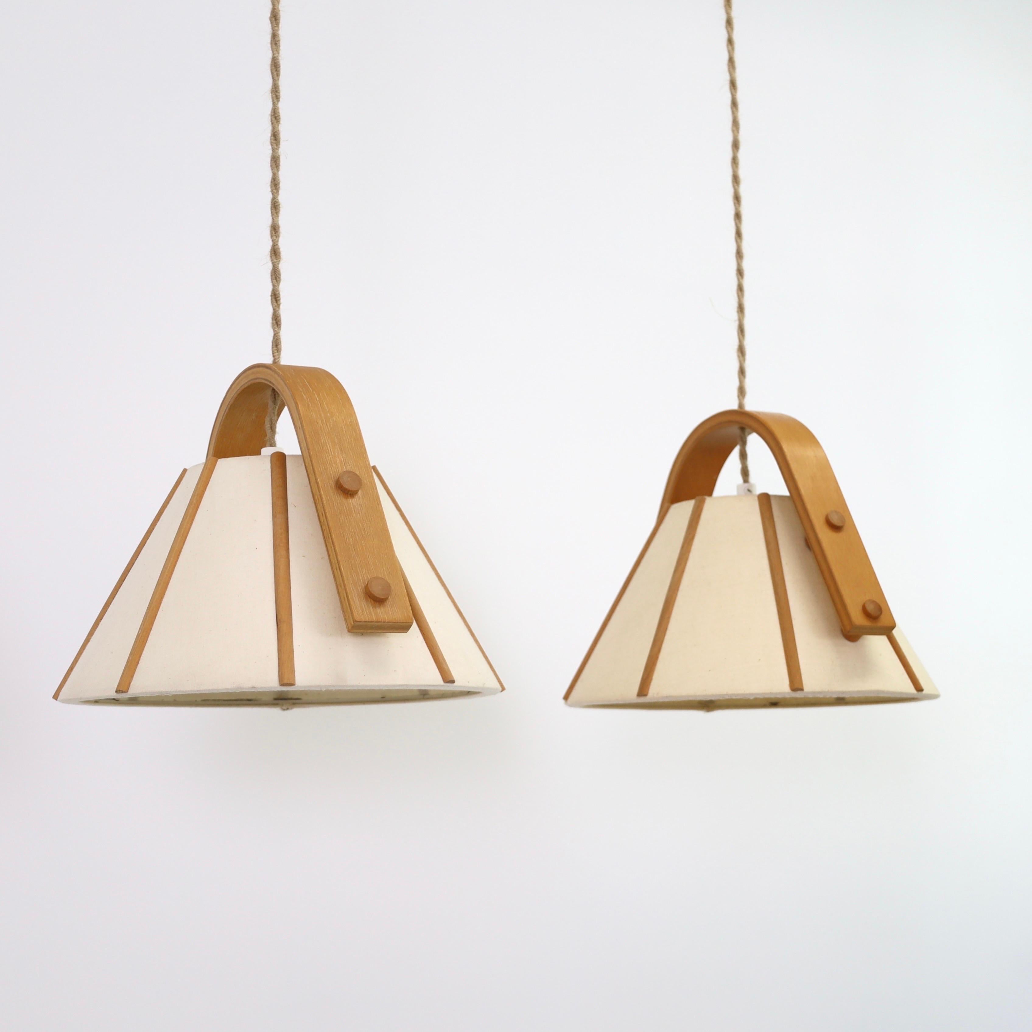 Coppia di lampade a sospensione in legno di faggio curvato con paralume in tela disegnate da Jan Wickelgren negli anni '70 per Aneta Sweden. Un bel set per un posto bellissimo. 

* Una coppia (2) di lampade a sospensione in impiallacciatura di