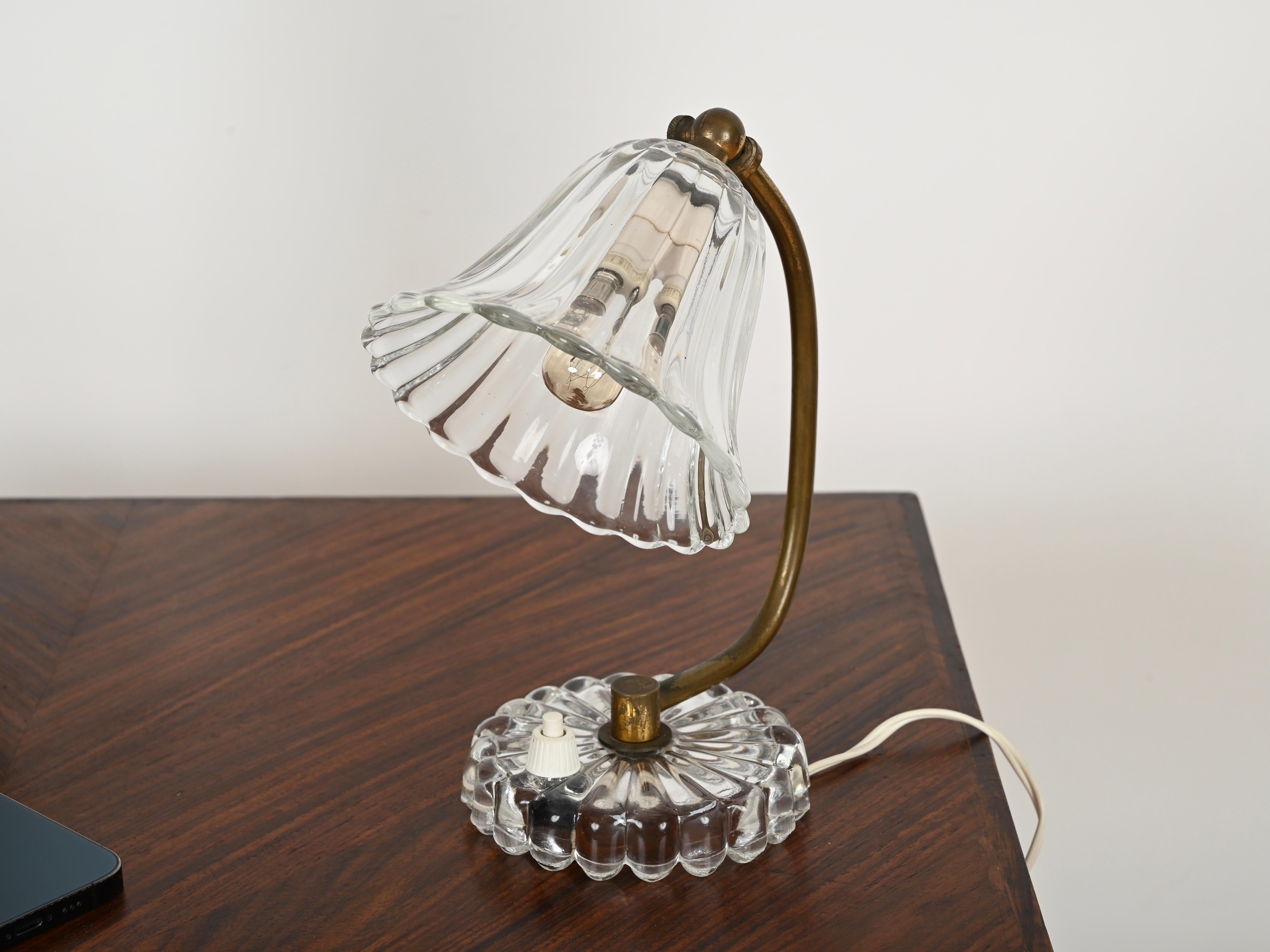 Stunning pair of bellflower Murano table lamps in mouth-blown crystal glass and brass. These incredibly elegant lamps were designed by Ercole Barovier and made in Italy during the early '40s.  

In spectacular conditions, with no chips or cracks,