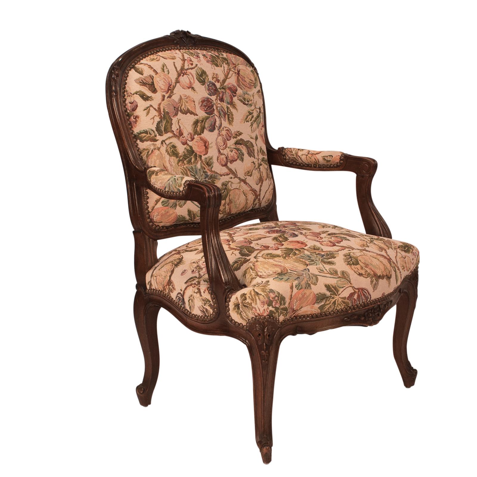 A pair of early 20th century French armchairs in the Louis XVI style, circa 1900 carved walnut with vintage tapestry upholstery. Good solid frames recently polished and tightened. In the style of Louis XV.